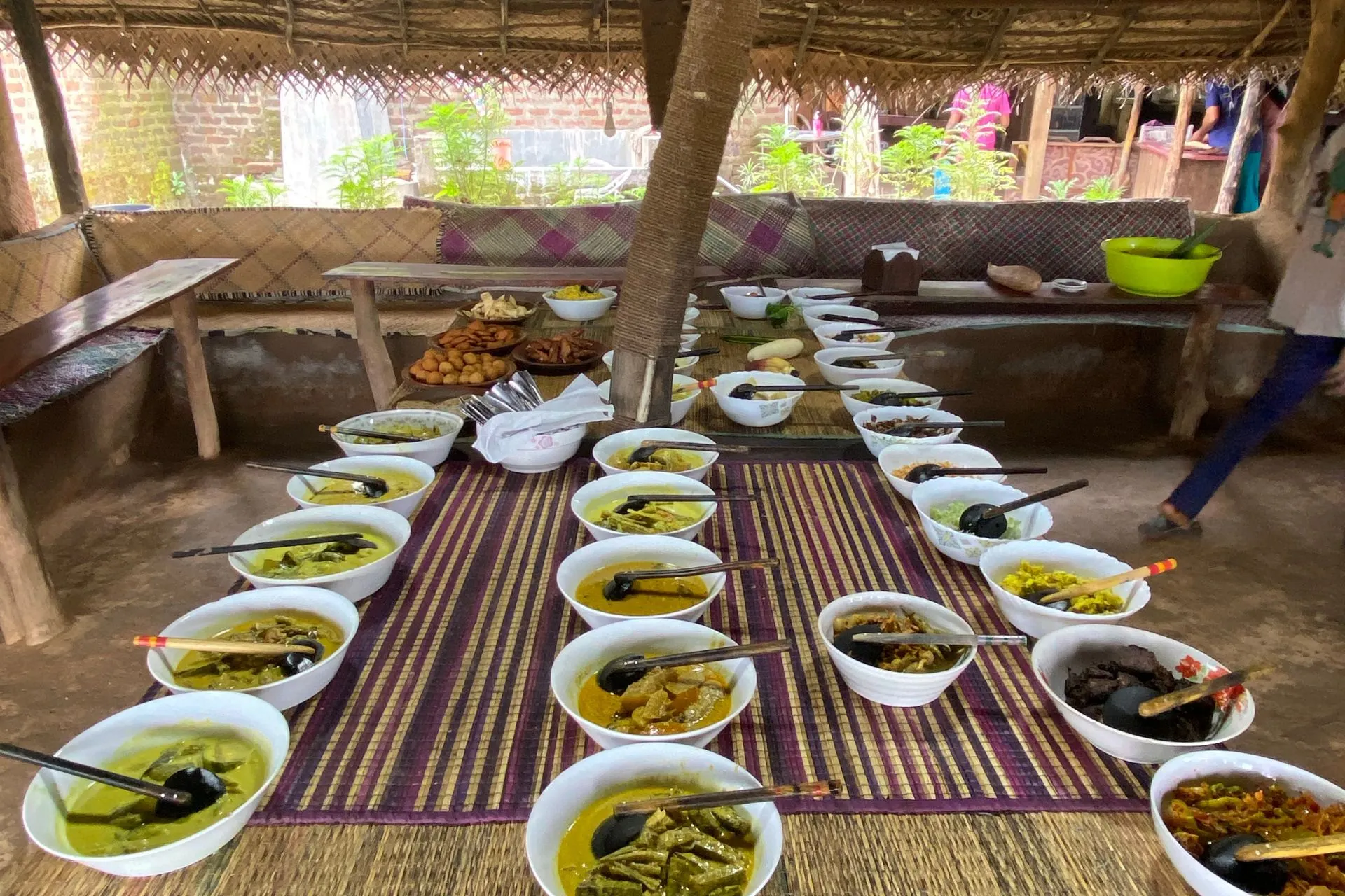 Tafel vol schalen met diverse Sri Lankaanse curry’s en bijgerechten in een open eetruimte.

