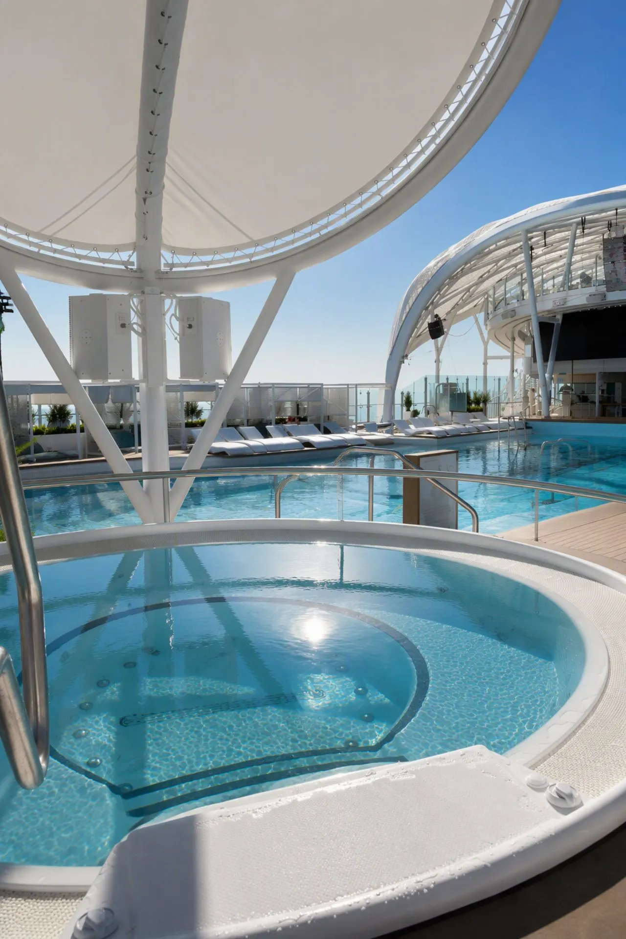 Moderne jacuzzi op het zonnedek van de Mein Schiff Flow met uitzicht op het zwembad en de omliggende ligbedden. Deze rustige wellnessruimte aan boord biedt gasten de mogelijkheid om volledig te ontspannen tijdens een zeedag. Dankzij het open ontwerp, de comfortabele voorzieningen en het uitzicht op zee is dit een populaire plek op het schip.