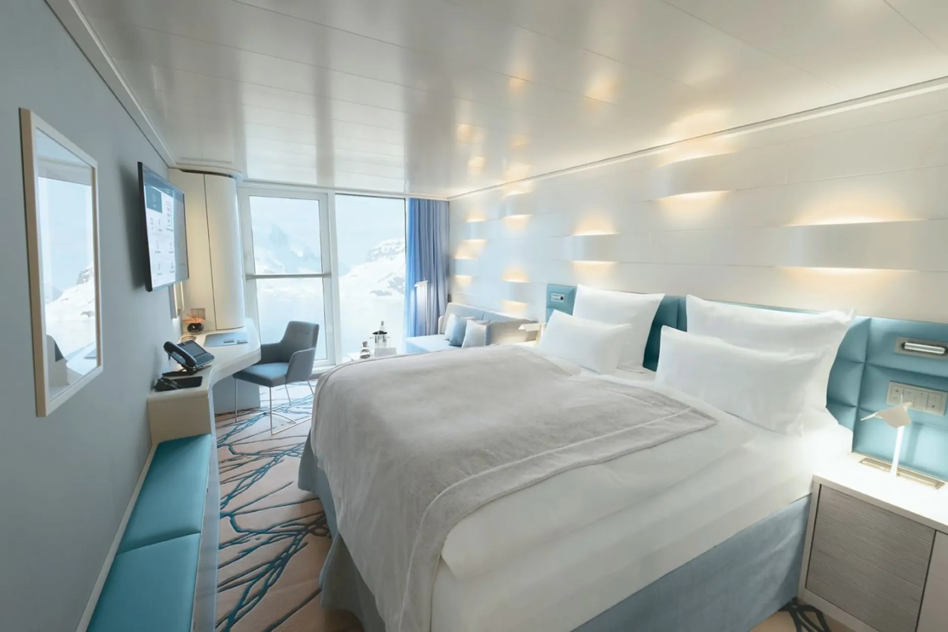 Luxe tweepersoonskamer in de Hanseatic Inspiration van Hapag Lloyd, stijlvol ingericht in wit en blauw met een groot comfortabel bed.