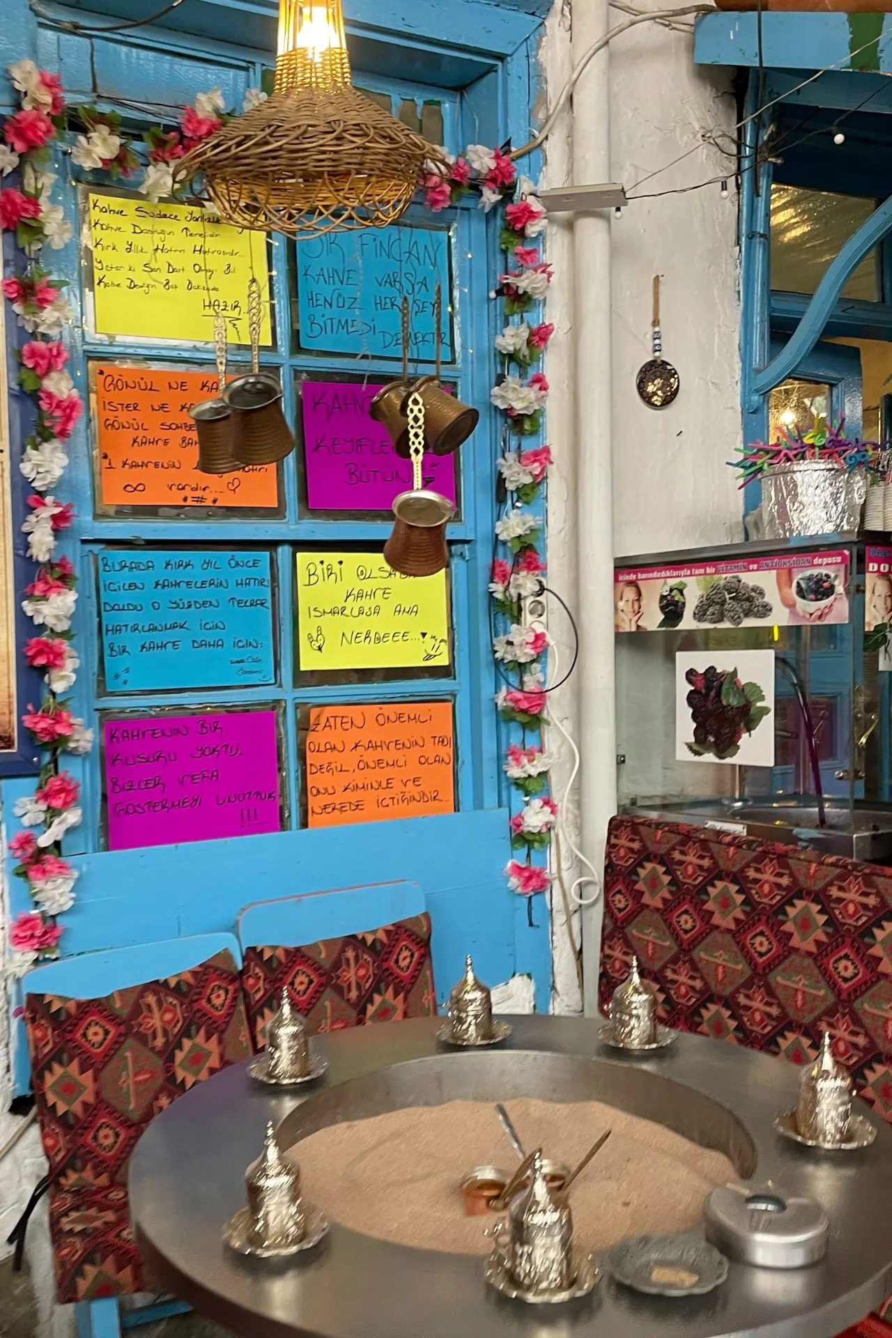 Traditionele koffiehoek in Şirince met felgekleurde bordjes met teksten, een zandkoffie-opstelling en authentiek Turks servies.