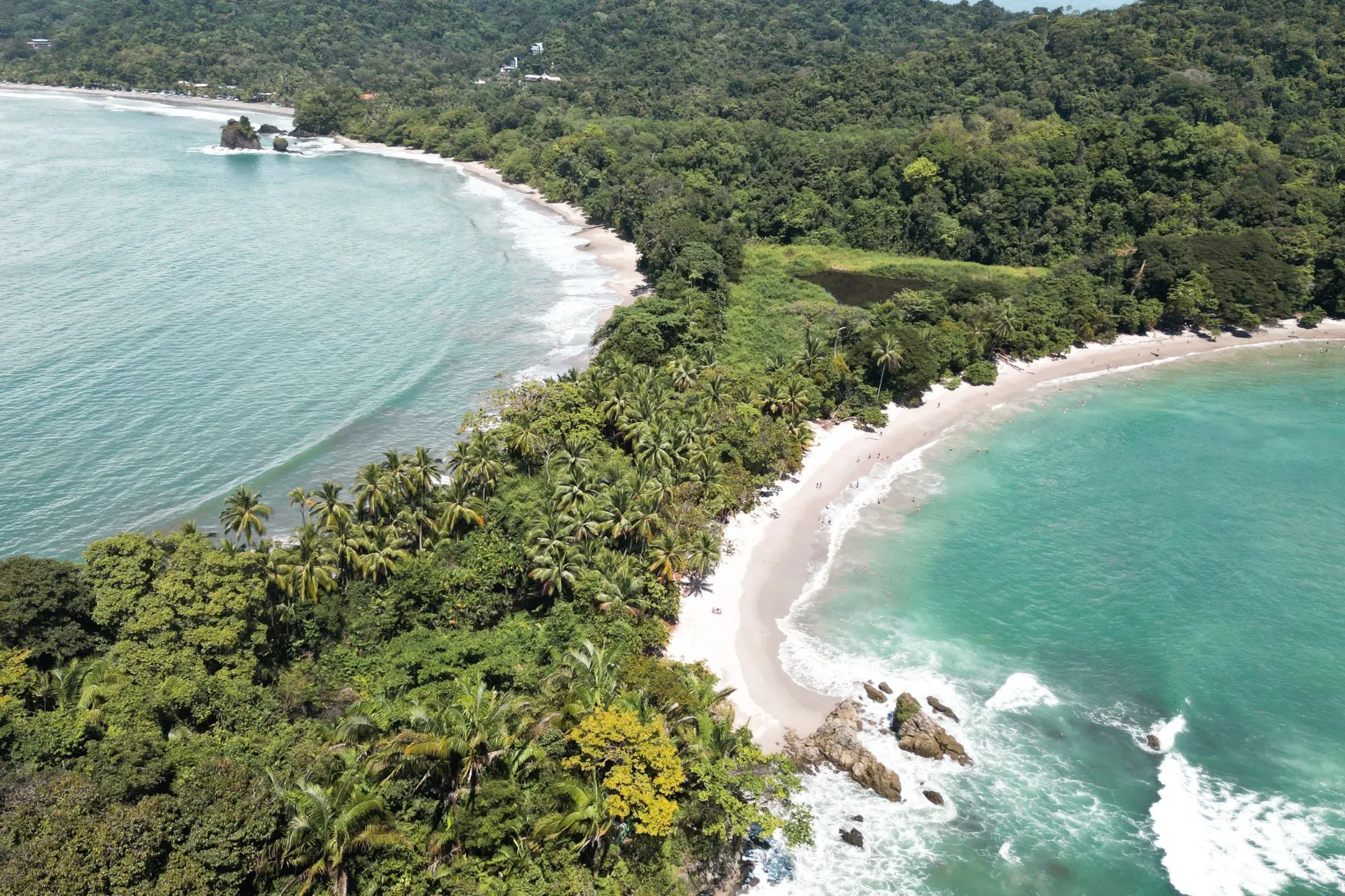 Luchtfoto van de tropische kustlijn en stranden van Manuel Antonio, Costa Rica, omgeven door weelderig groen.