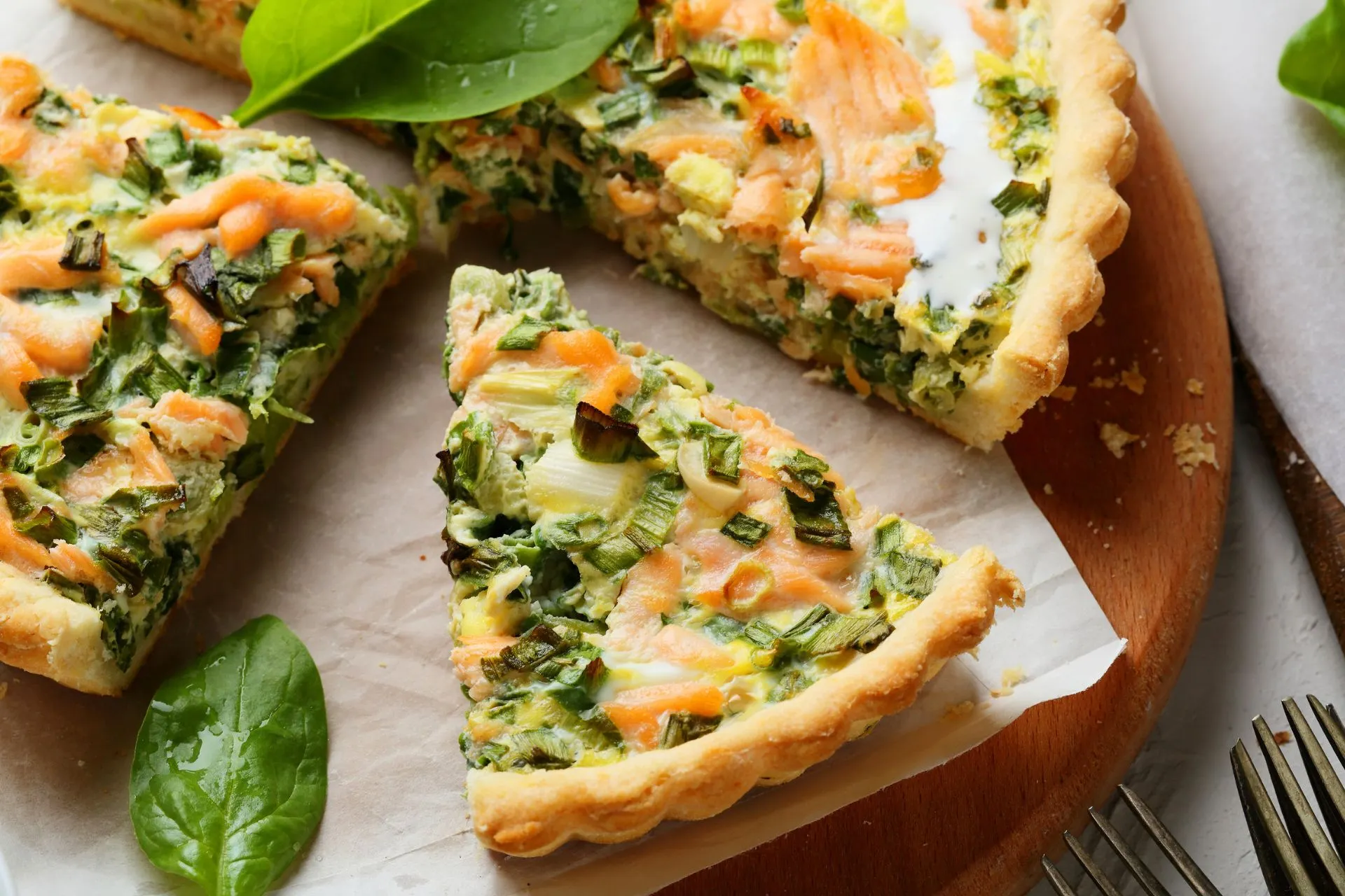 Een smakelijke quiche in Parijs, gevuld met zalm en spinazie, geserveerd als een lichte en voedzame lunch in een gezellig café.