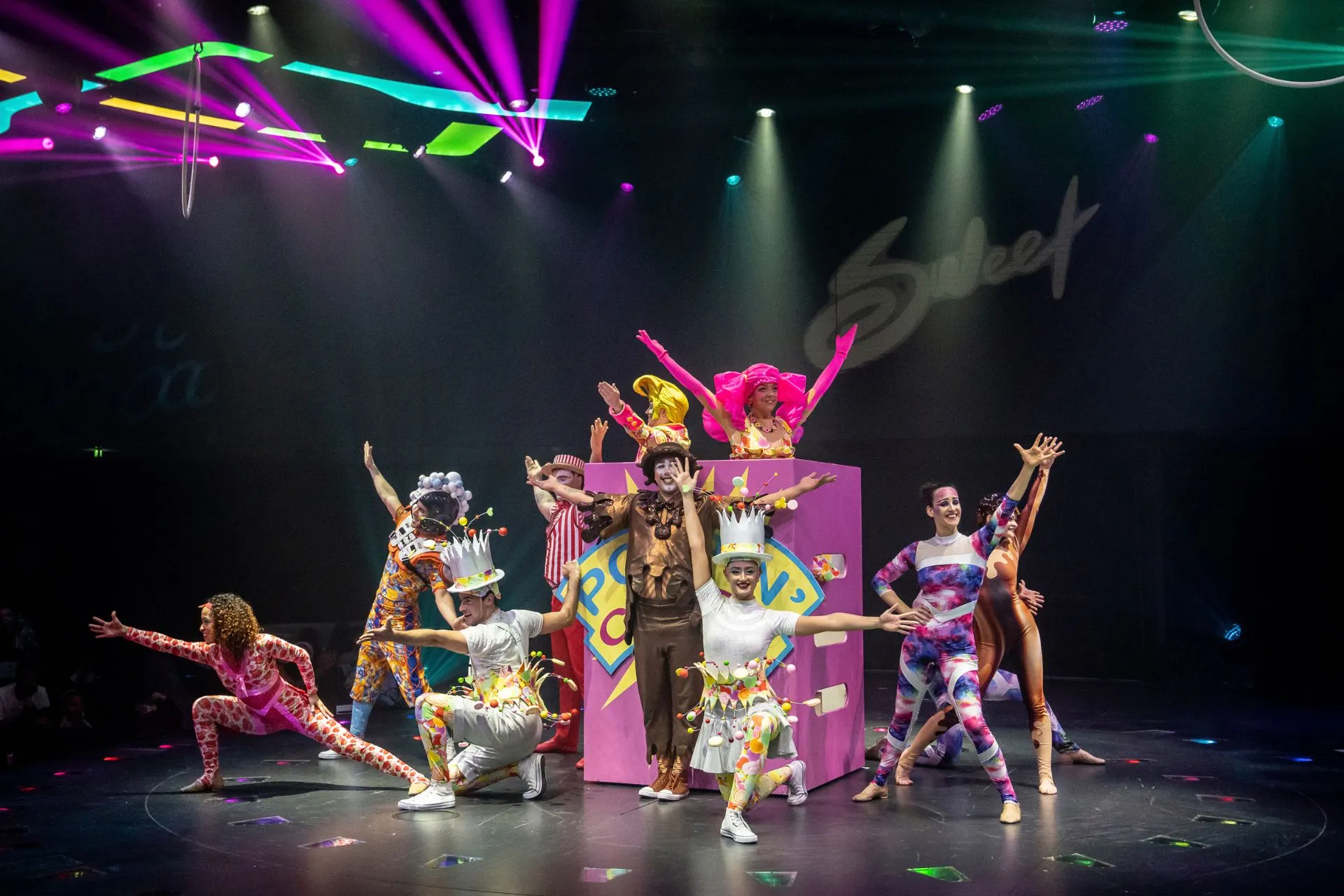 Kleurrijk uitgedoste artiesten voeren een spectaculaire theatershow op met acrobatiek en dans, onder felle lichten aan boord van een MSC cruiseschip.