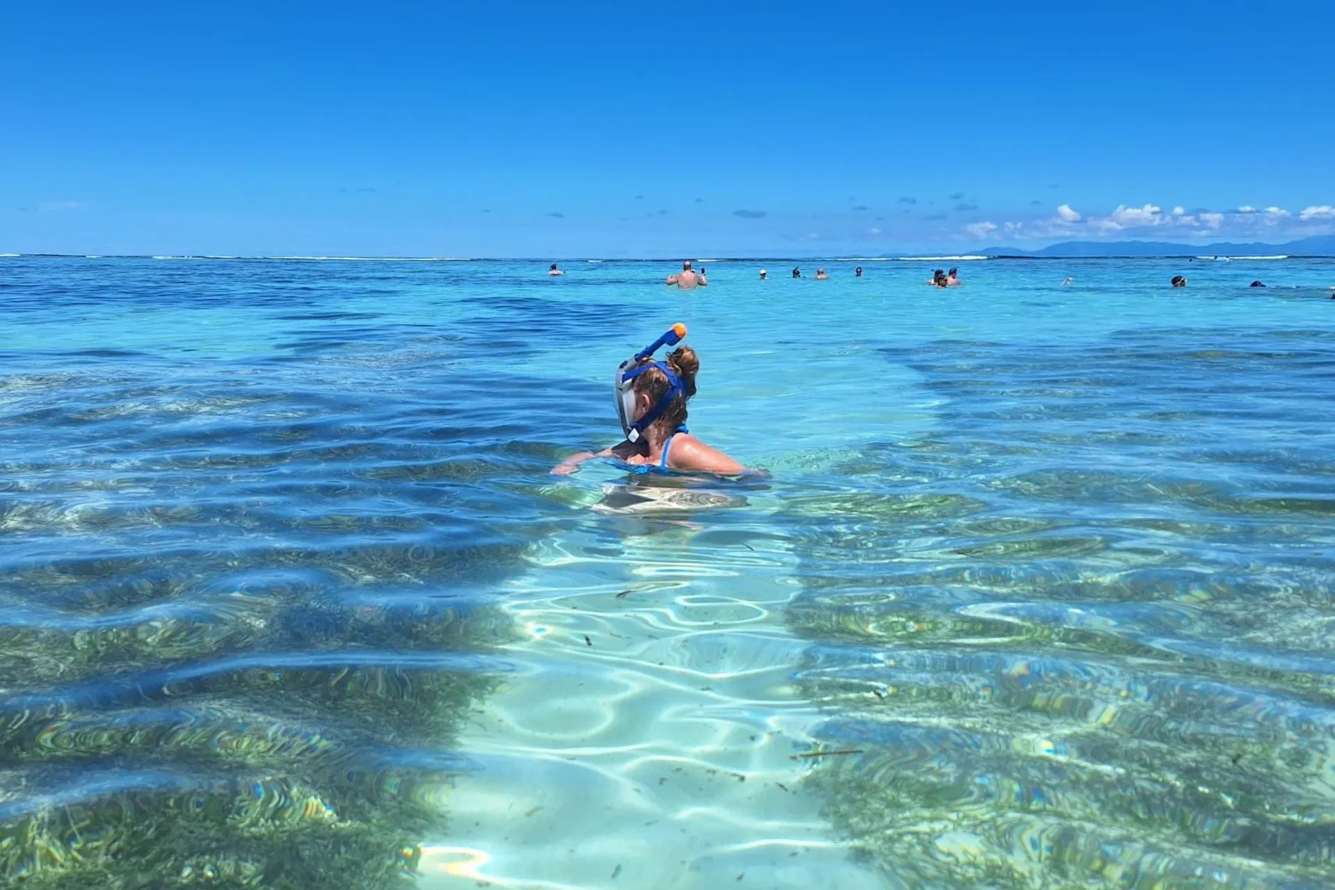 Reisspecialist Karin snorkelt in het kristalheldere water van Blue Bay Mauritius, omringd door andere snorkelaars in de lagune