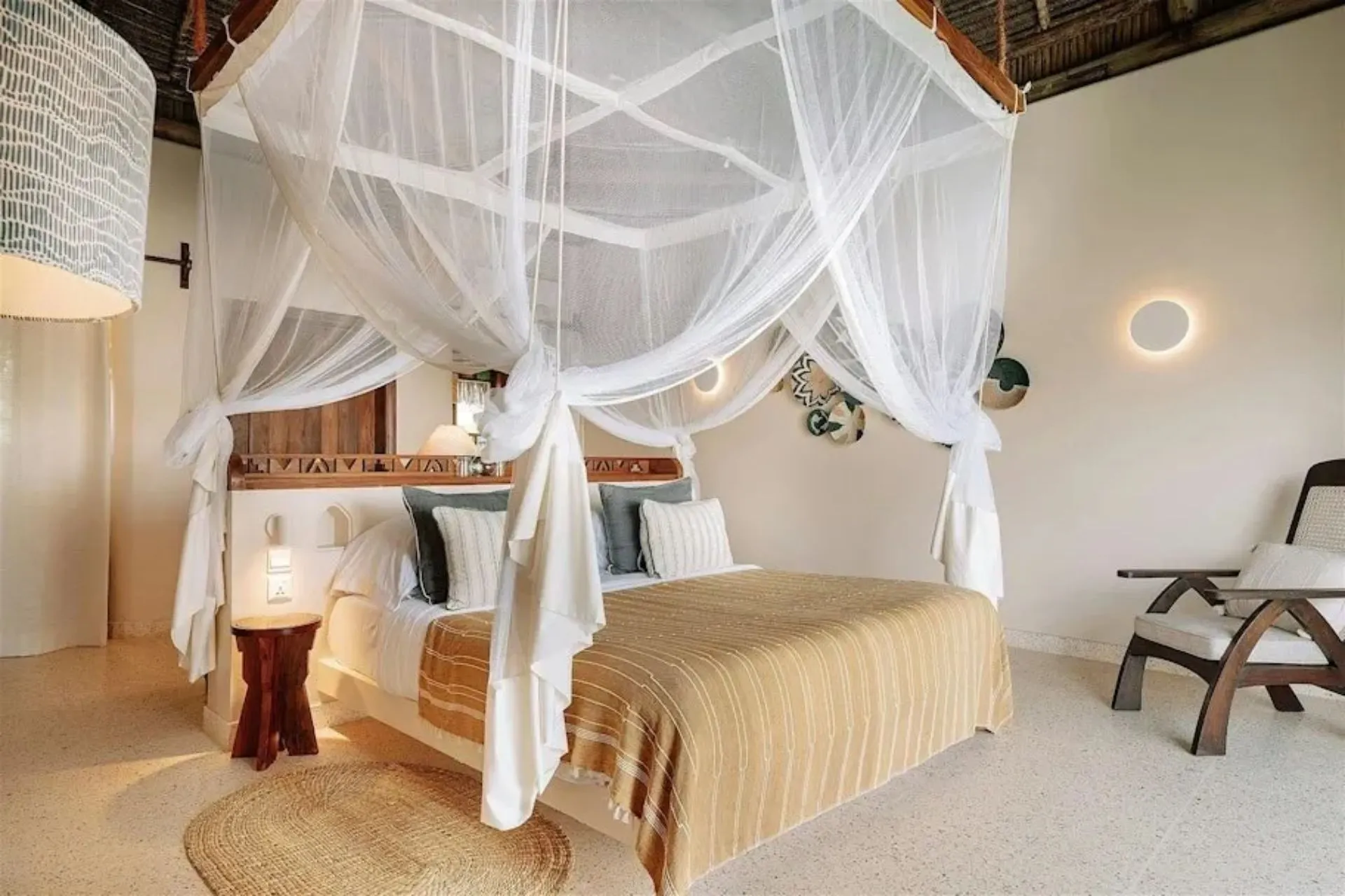 Luxe villa van Matemwe Attitude op Zanzibar met een hemelbed voorzien van klamboe, natuurlijke materialen en een elegante inrichting in Swahili-stijl. Dit adults only resort biedt ruime accommodaties, veel privacy en een ontspannen sfeer midden in de tropische natuur van Zanzibar.