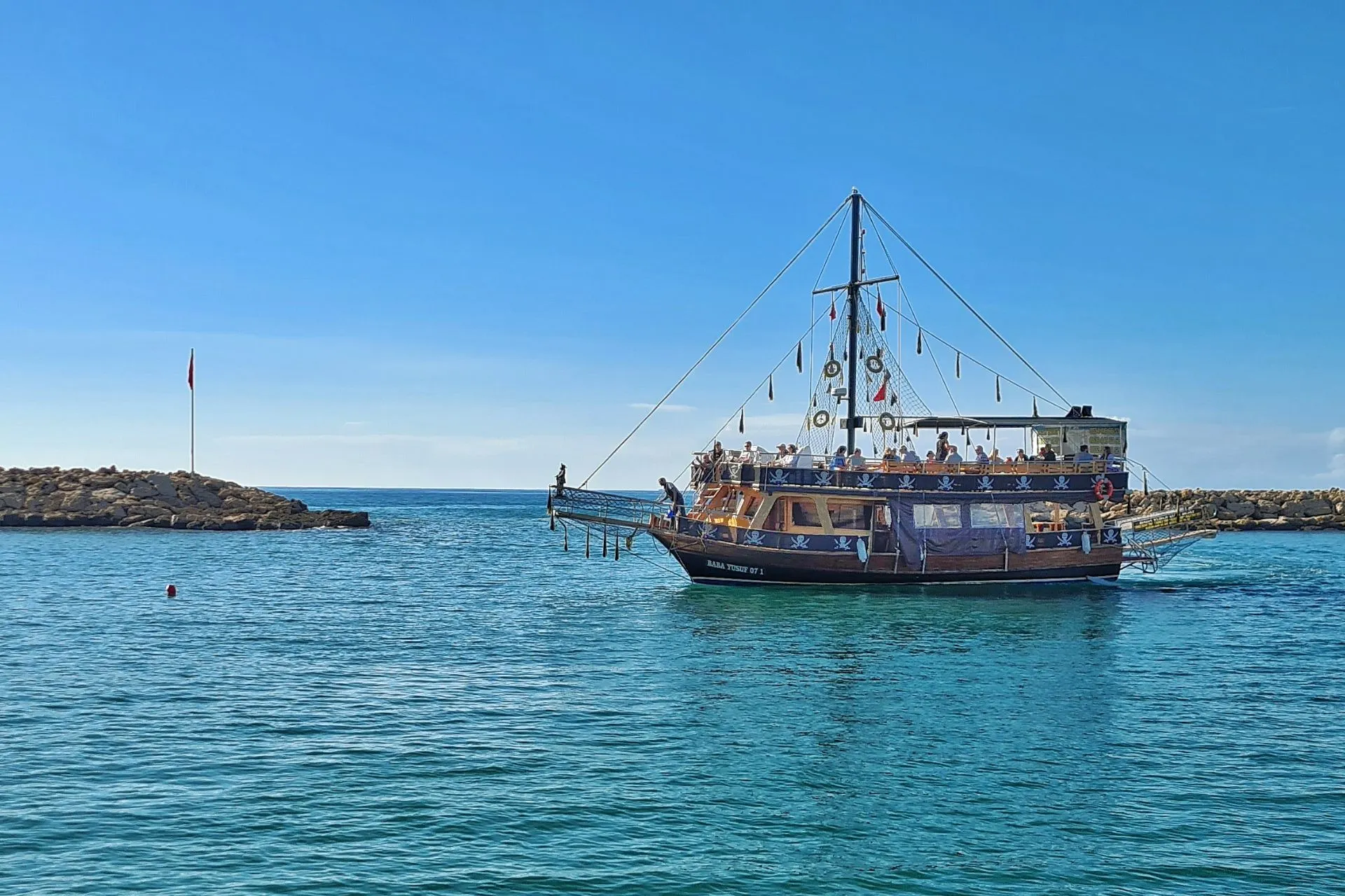 Traditionele excursieboot vaart vanuit de haven van Side over het helderblauwe water van de Middellandse Zee. Boottochten langs de Turkse kust behoren tot de populairste activiteiten in de omgeving van Side en bieden prachtige uitzichten op stranden, baaien en de historische kustlijn van de Turkse Rivièra.

