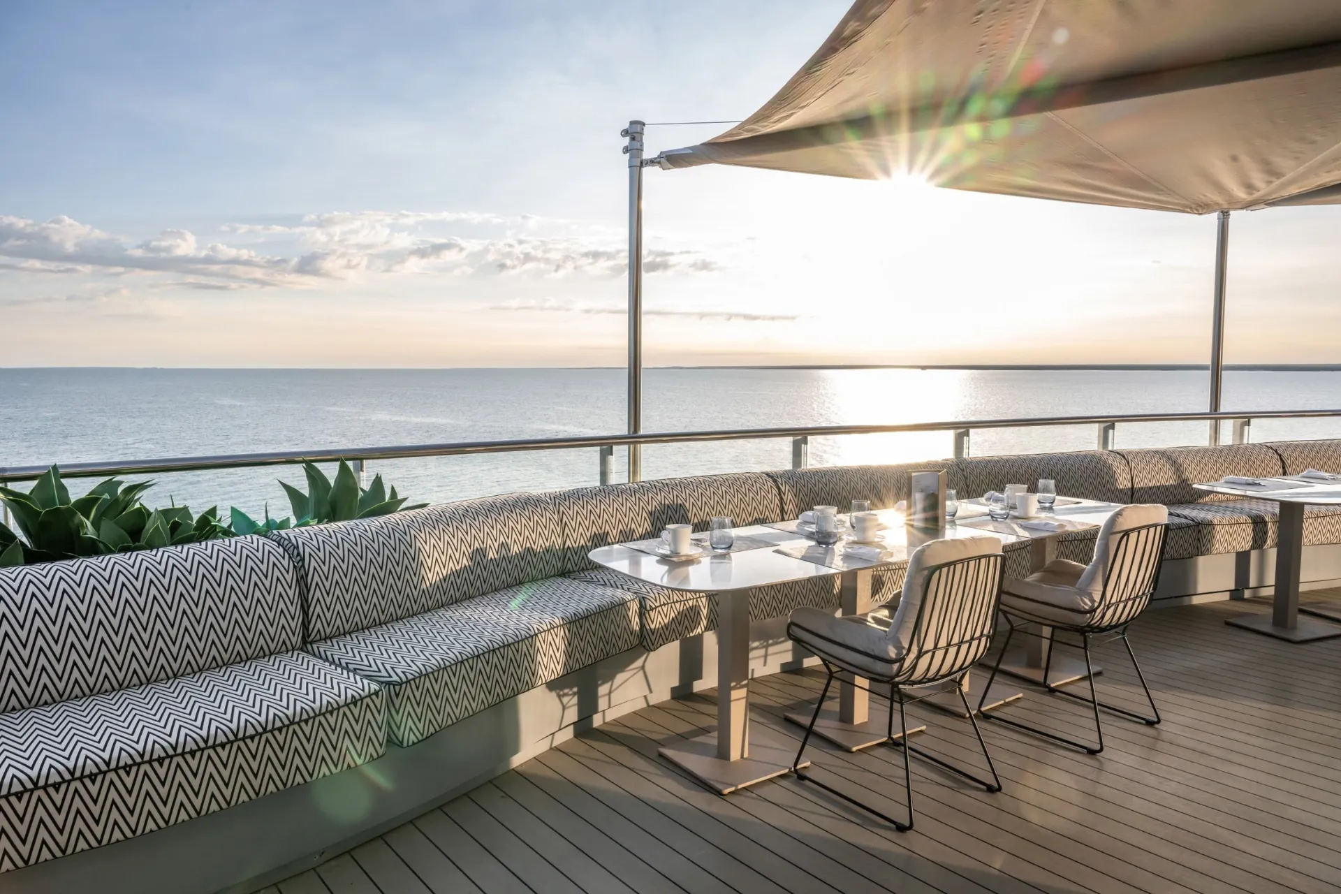 Uitzicht vanaf het dek van Scenic Eclipse op de zee met een stralende zon aan de hemel