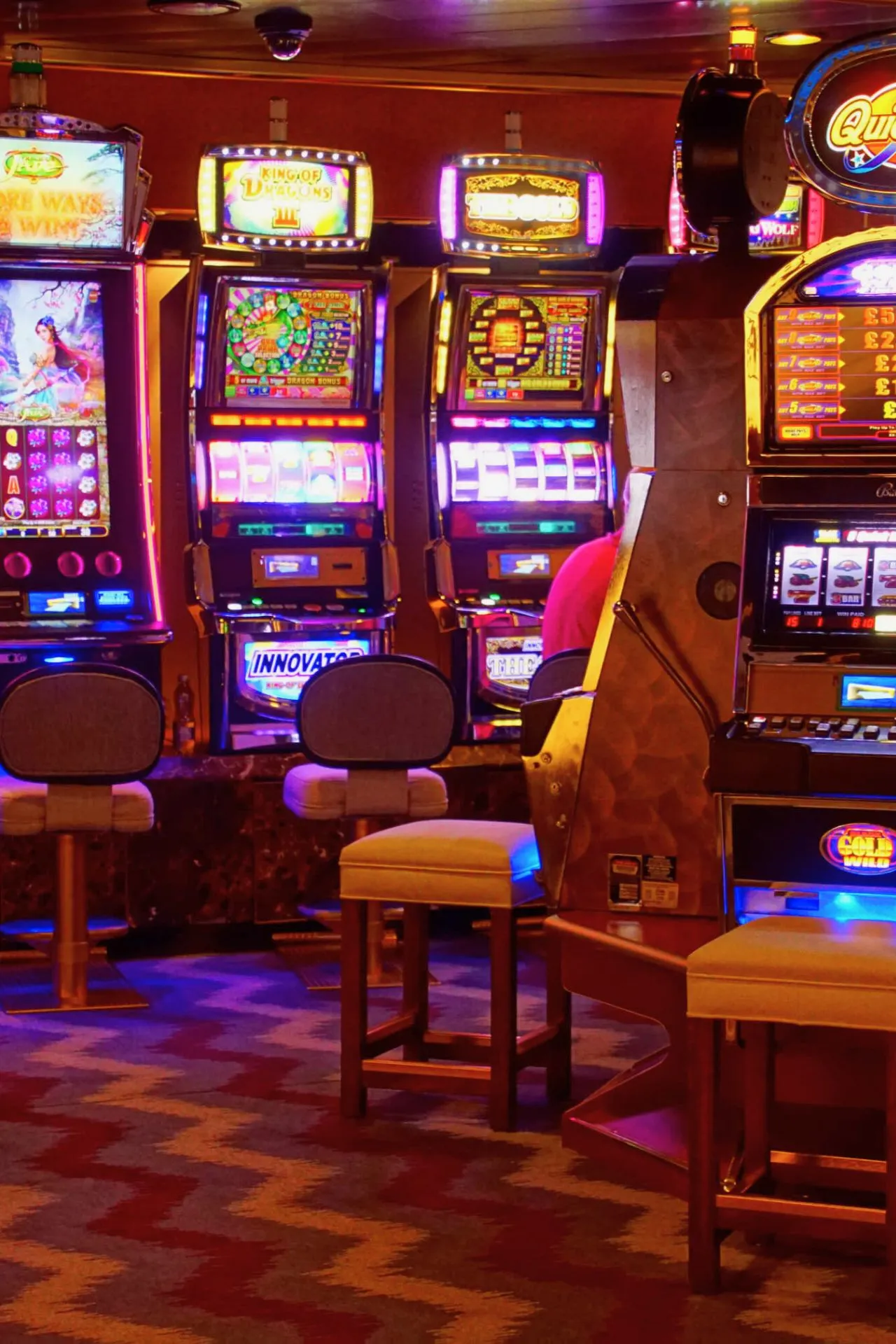 Fel verlichte gokkasten met kleurrijke displays in een casino.
