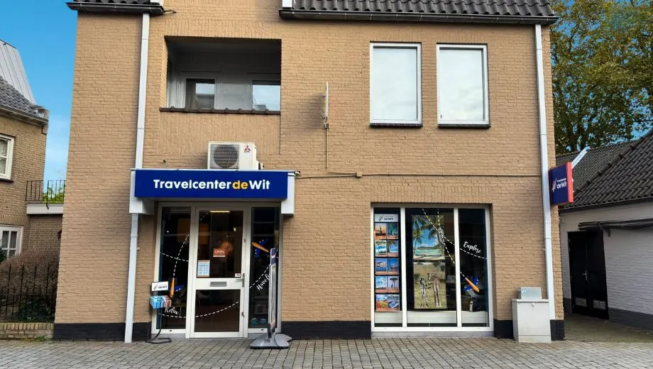 Filiaal Rosmalen van Travelcenter de Wit, hoekig gebouw met stoepbord buiten.