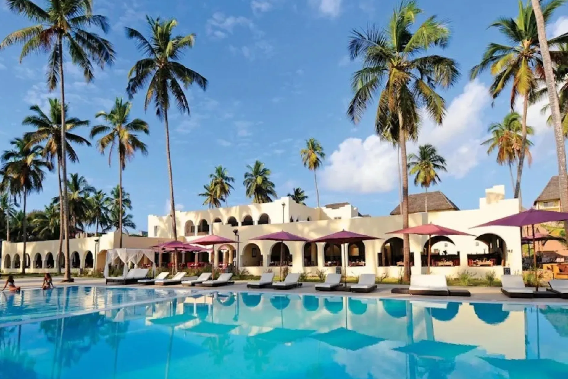 Het tropische resort TUI BLUE Bahari Zanzibar met traditionele architectuur, rieten daken, palmbomen en een ruim zwembad. De verzorgde tuinen, comfortabele ligbedden en ontspannen sfeer maken dit hotel een geliefde keuze voor een luxe all-inclusive vakantie op Zanzibar.