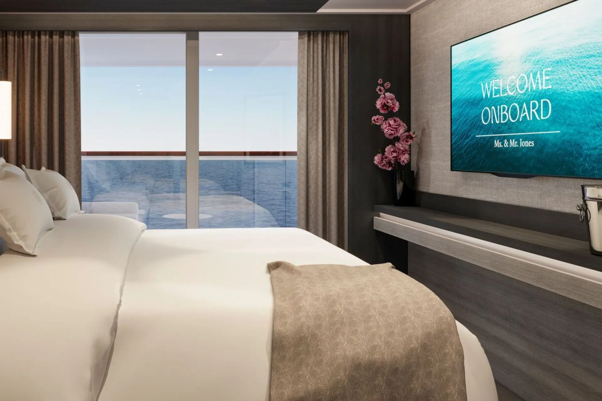 Luxe cruise suite met modern interieur, kingsize bed en panoramisch uitzicht op de oceaan via een privébalkon. De kamer is stijlvol ingericht met neutrale tinten, een elegante vaas met bloemen en een flatscreen-tv met welkomstbericht. Perfect voor een premium cruisevakantie met comfort, rust en exclusieve service. Ideaal voor reizigers die genieten van een ontspannen verblijf op een luxe cruiseschip met adembenemend zeezicht. Explora Journeys.