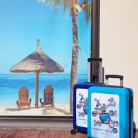 Zijkijk van twee blauwe handbagage trolleys van Travelcenter de Wit, stralend onder de zon. De koffers hebben een stevig, modern ontwerp en zijn uitgerust met vier wielen voor ultiem gemak tijdens reizen. De zonnige sfeer benadrukt de ideale keuze voor vakantiegangers op zoek naar een praktische en stijlvolle reistas.