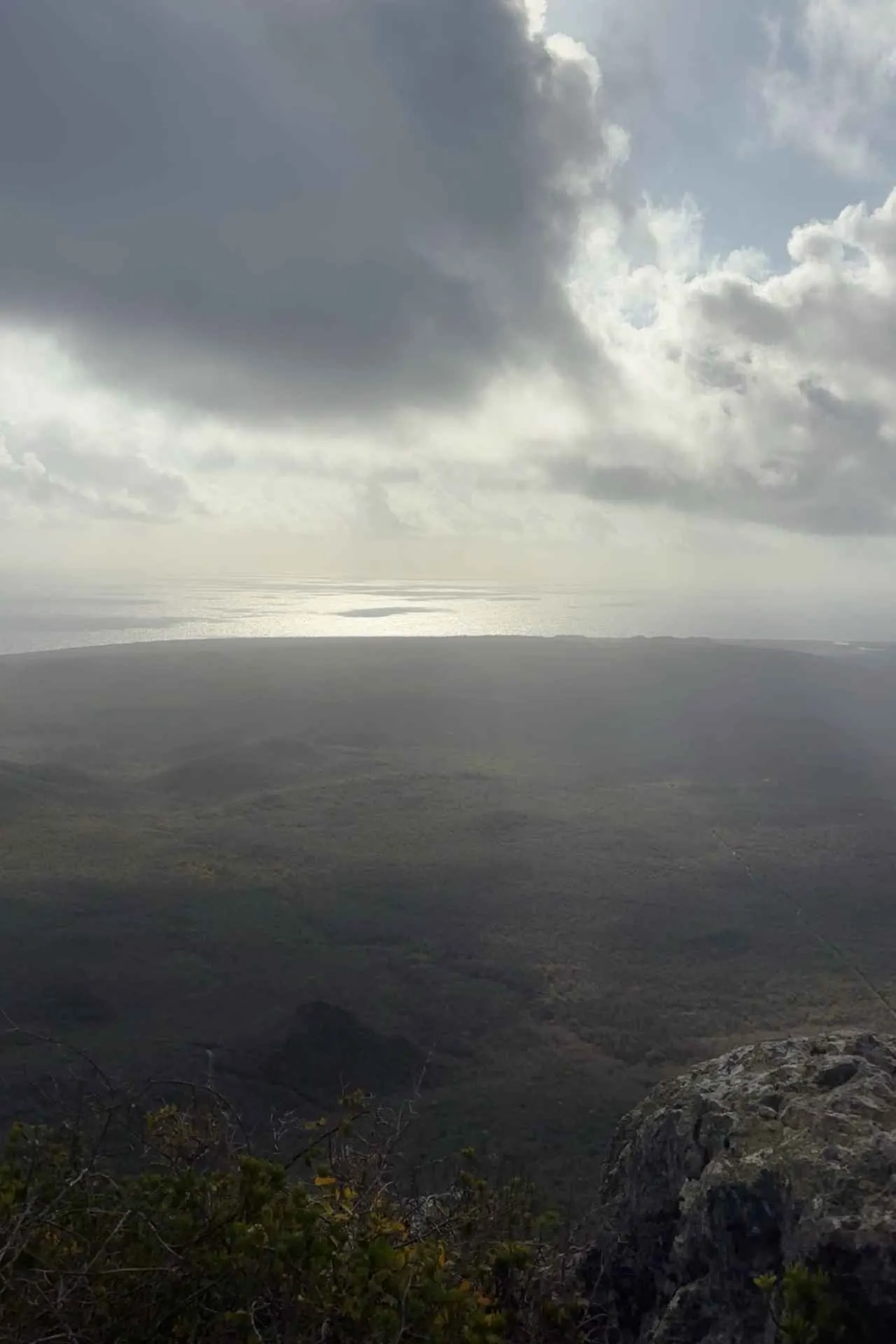 Uitzicht vanaf de top van de Christoffelberg over de groene natuur en kustlijn van Curaçao.