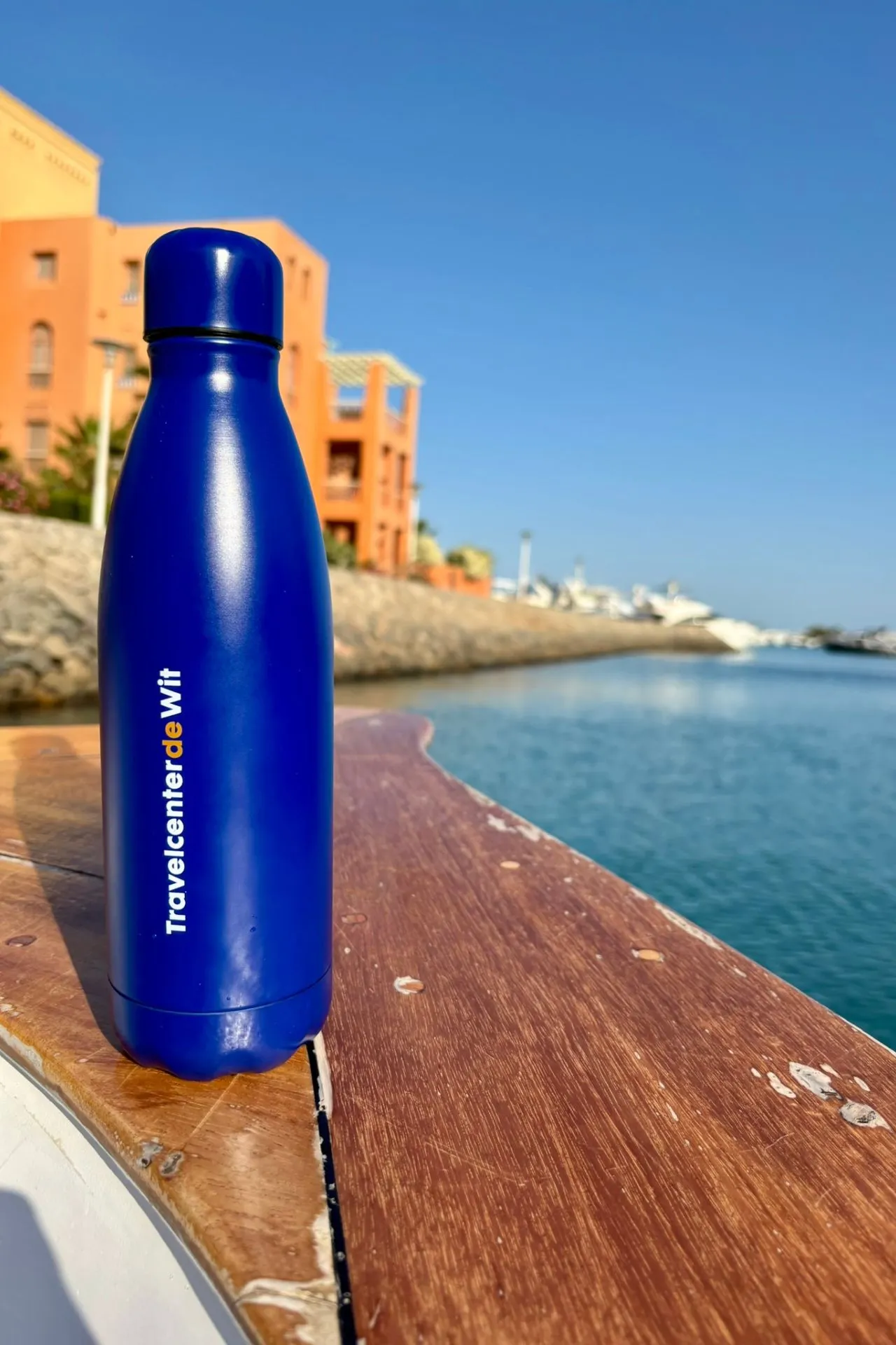 Blauwe Travelcenter de Wit drinkfles bij de jachthaven van El Gouna met water en boten op de achtergrond