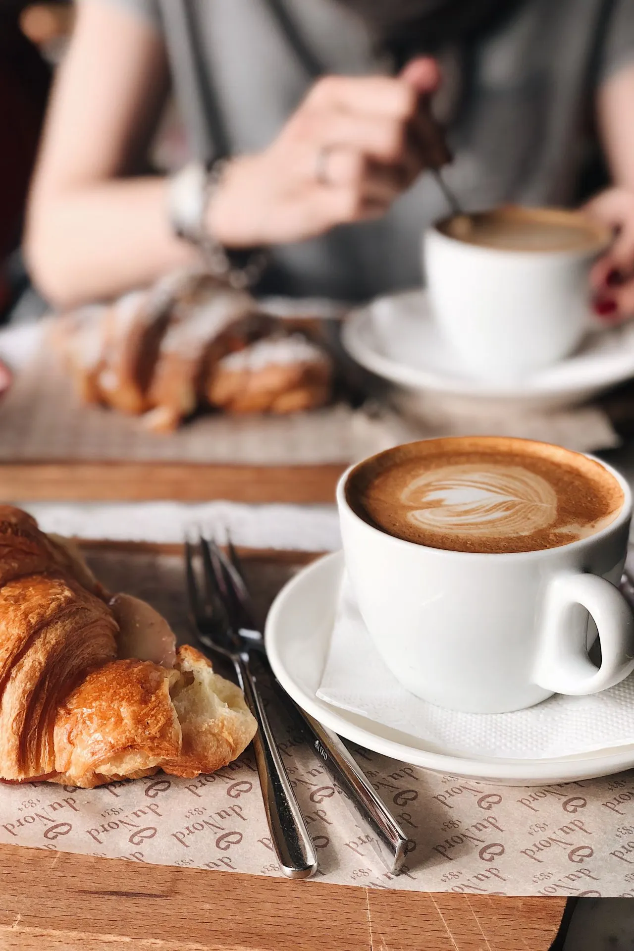 Een typisch Parijse ontbijt met een versgebakken croissant en een kopje koffie, geserveerd in een charmant café in Parijs.