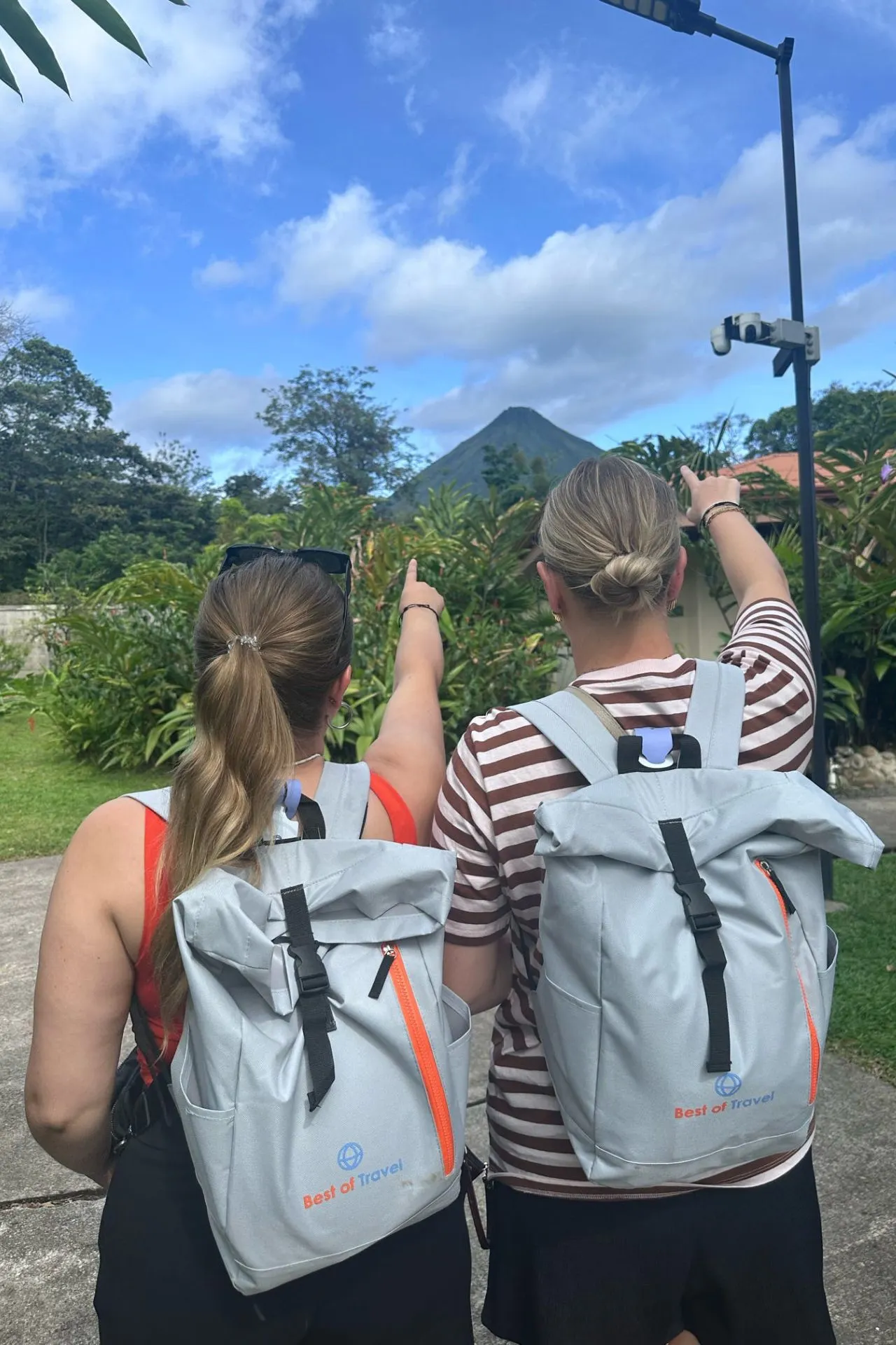 Reizigers bewonderen de iconische Arenal-vulkaan in La Fortuna, Costa Rica. De vulkaan vormt het decor van tal van avontuurlijke activiteiten, waaronder wandelen, wildlife spotten en ontspannen in warmwaterbronnen.