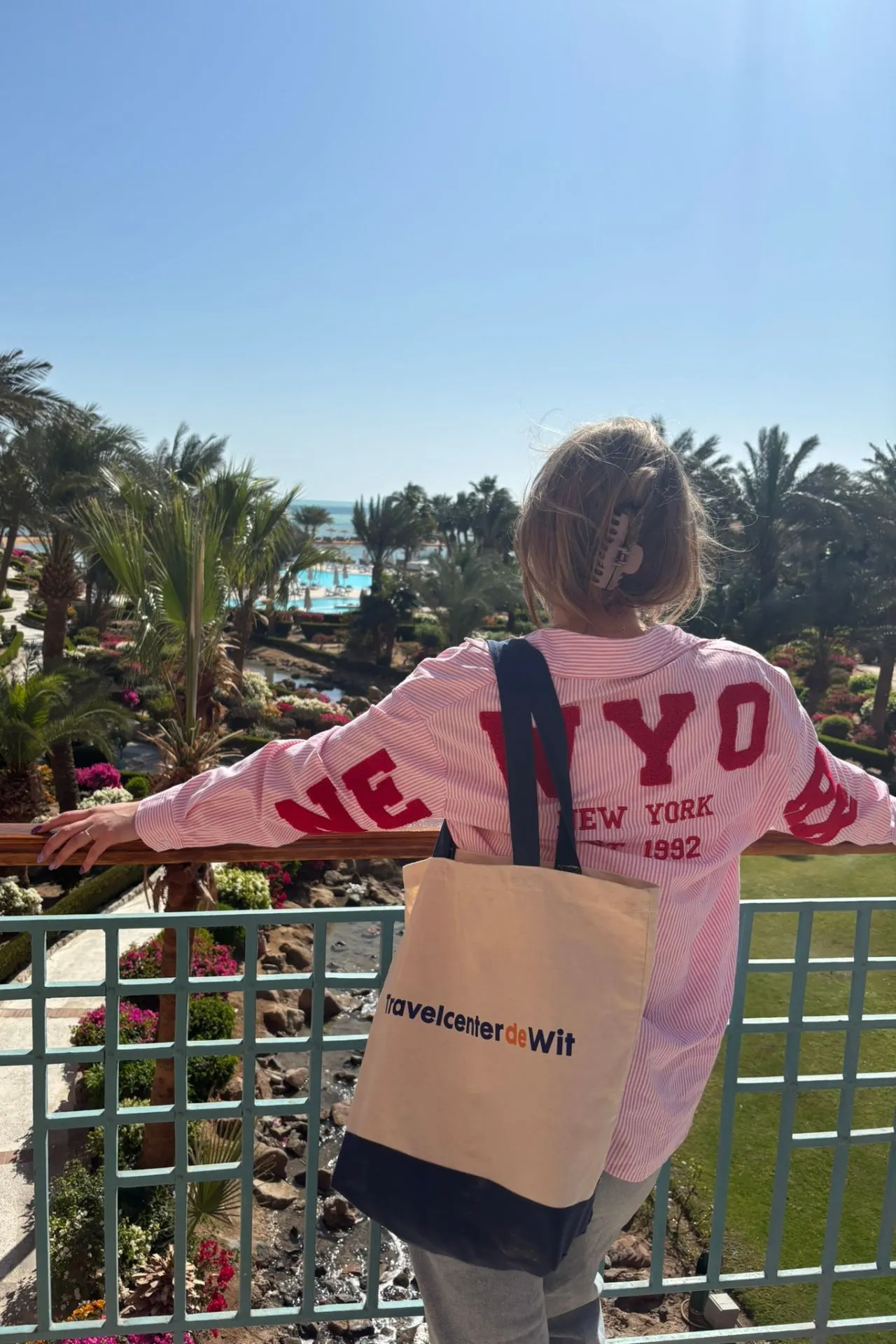 Reisspecialist van Travelcenter de Wit met tas van Travelcenter de Wit kijkt uit over het Mövenpick Resort & Spa El Gouna in Egypte
