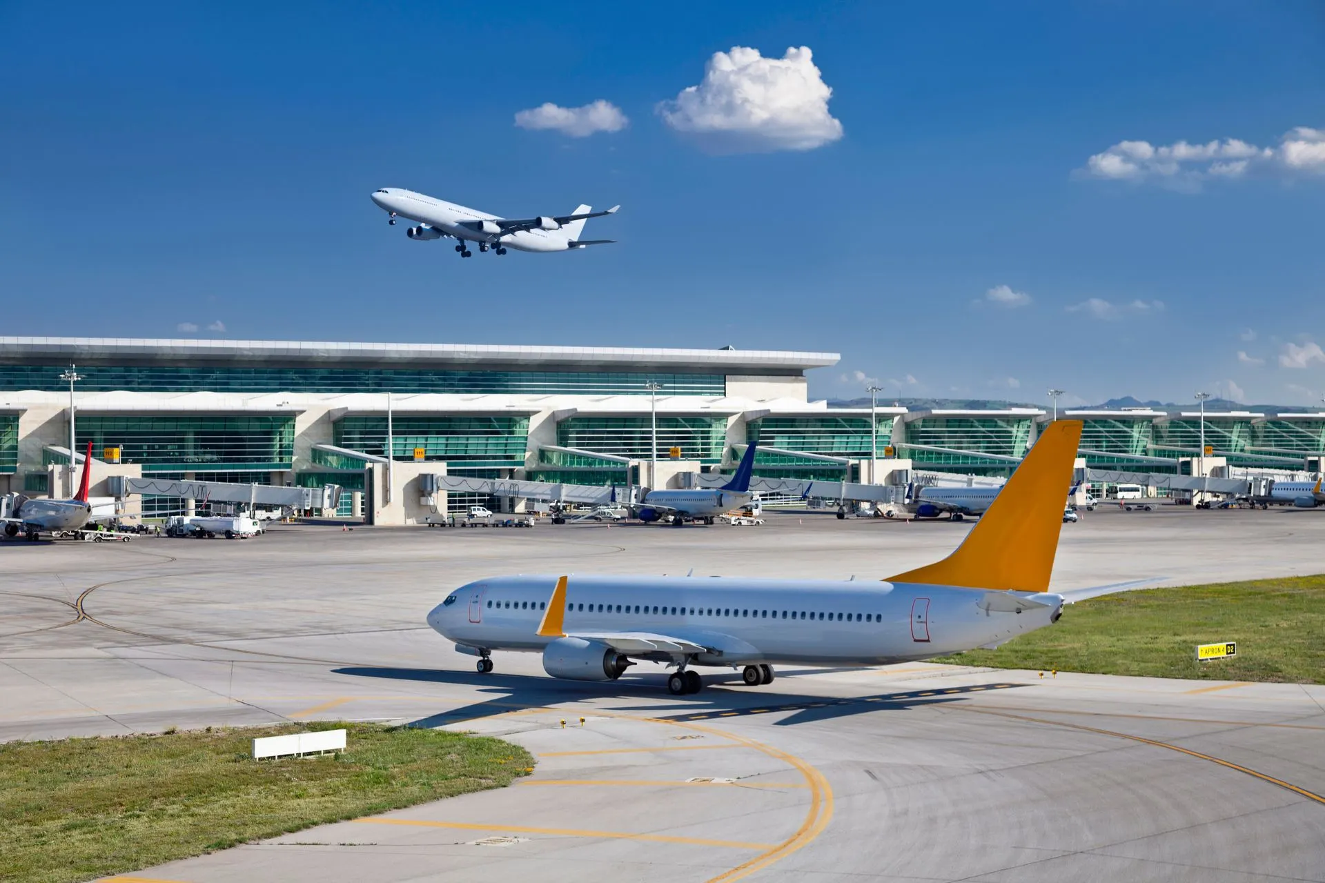 Een vliegtuig dat opstijgt en een ander vliegtuig dat over de taxibaan rijdt bij luchthaven Eindhoven. Vluchten vanaf Eindhoven Airport brengen je naar diverse populaire Europese bestemmingen voor zowel stedentrips als zonvakanties.