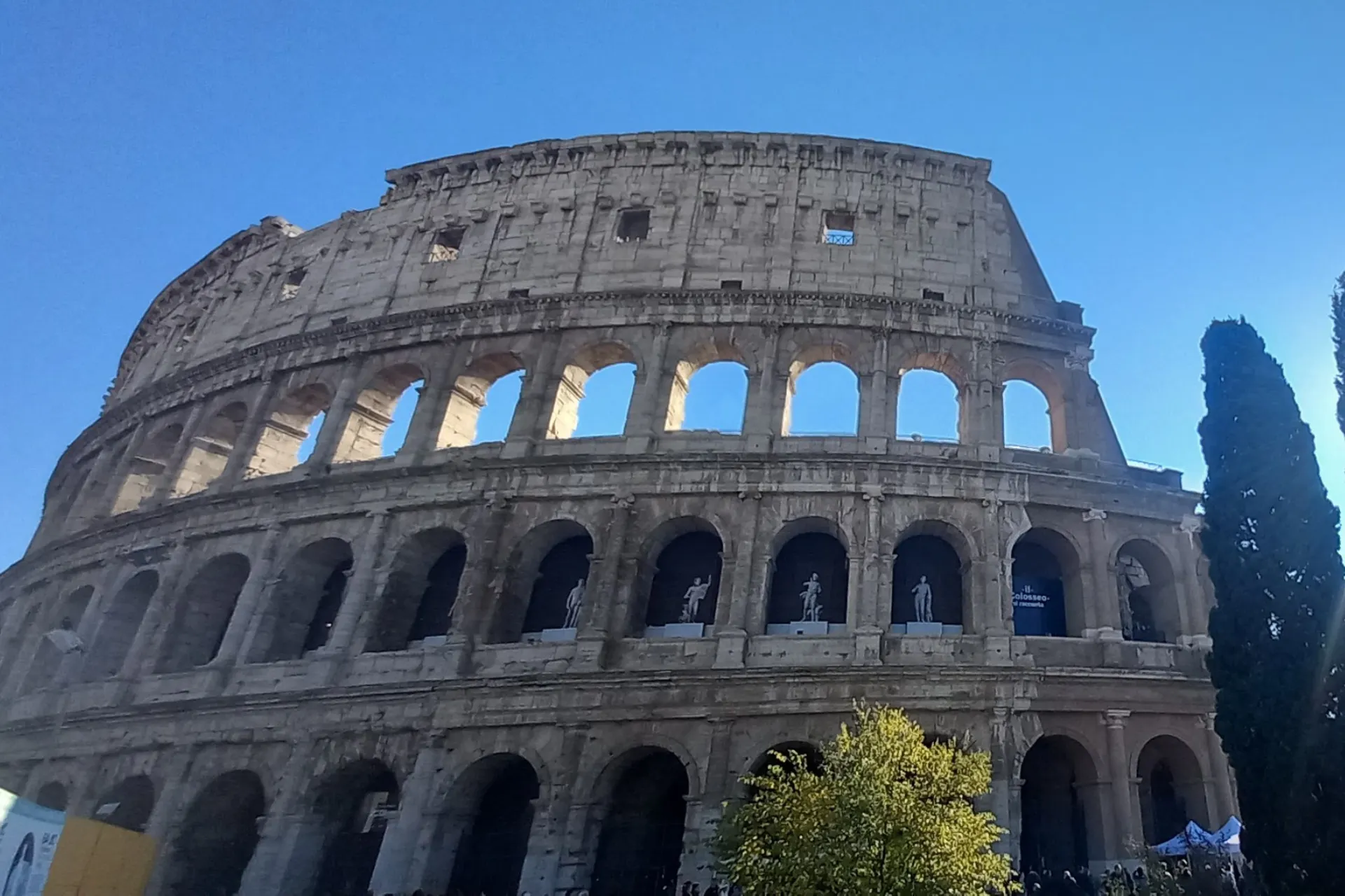 Het indrukwekkende Colosseum in Rome, met een strakblauwe lucht op de achtergrond.