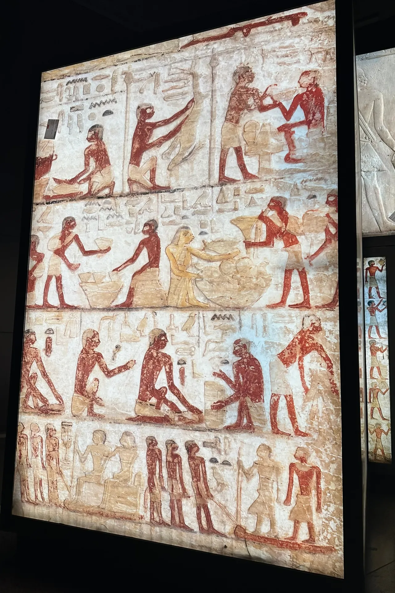 Oude Egyptische tekeningen en hiërogliefen op een stenen muur.