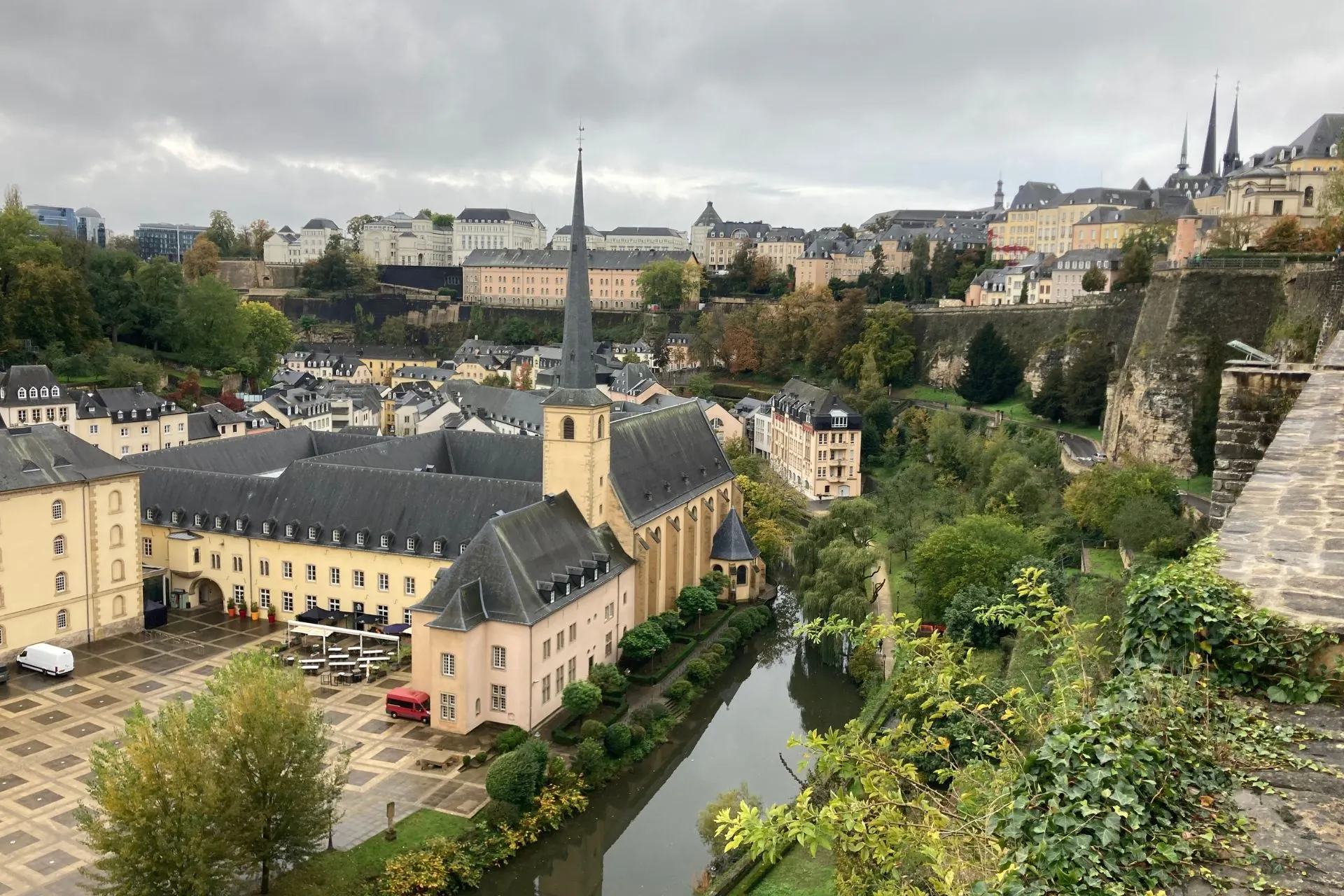 Luchtfoto van Luxemburg Stad met een kerk, kronkelende rivier en omliggende historische gebouwen.