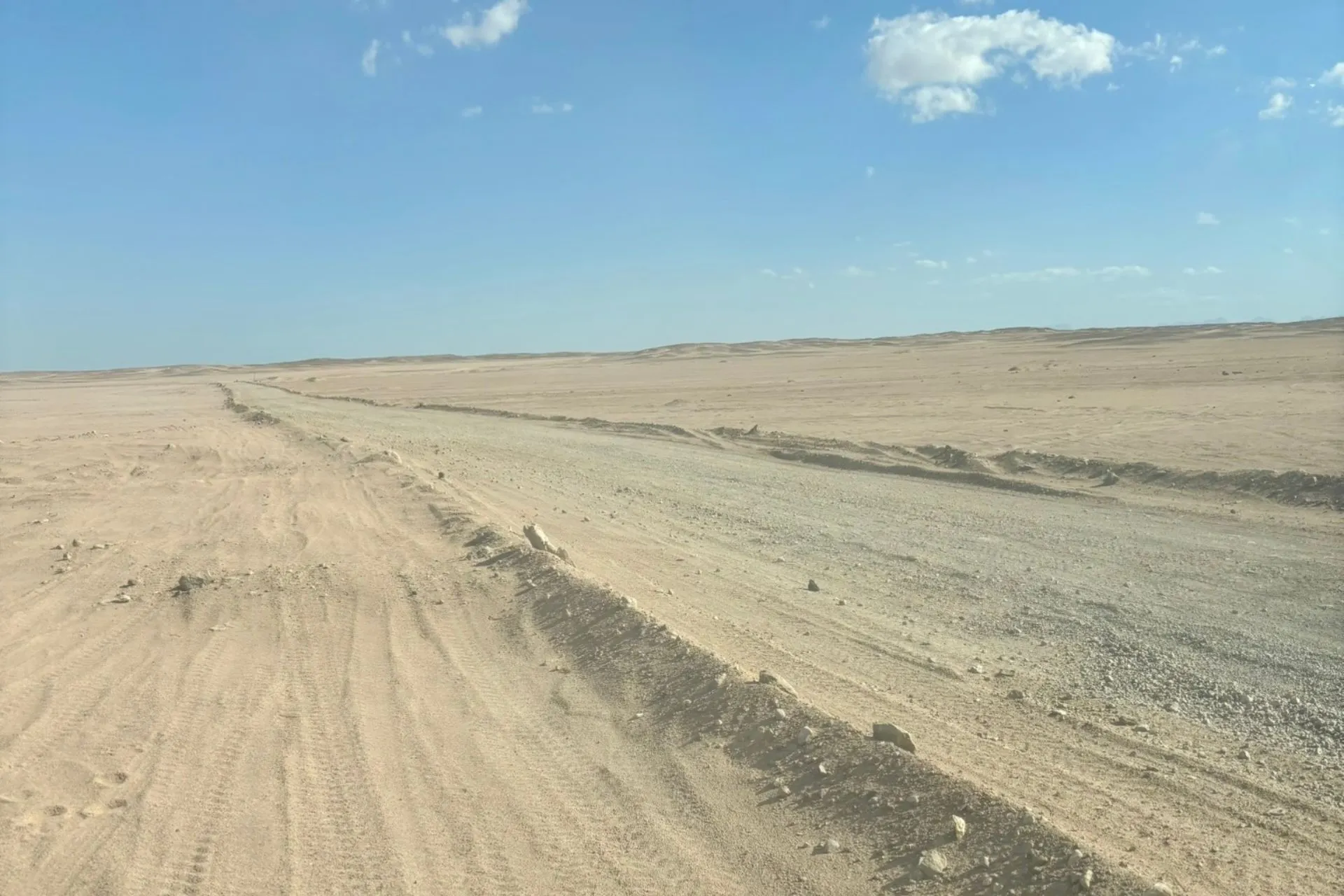 Uitgestrekt woestijnlandschap in Egypte met zandwegen en rijsporen tijdens een jeepsafari.