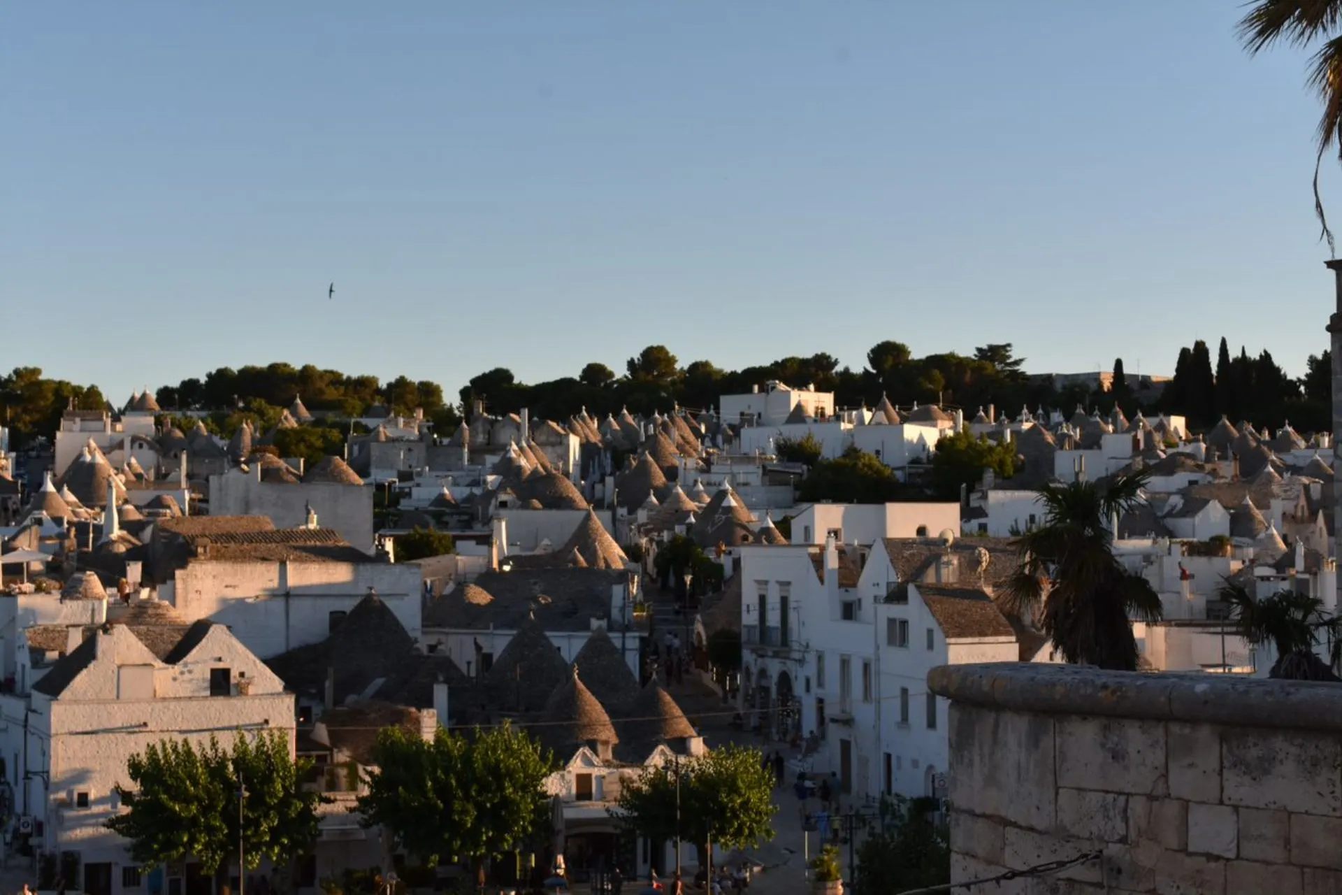 Uitzicht over de karakteristieke trulli-huizen van Alberobello in het zachte licht van de ondergaande zon.