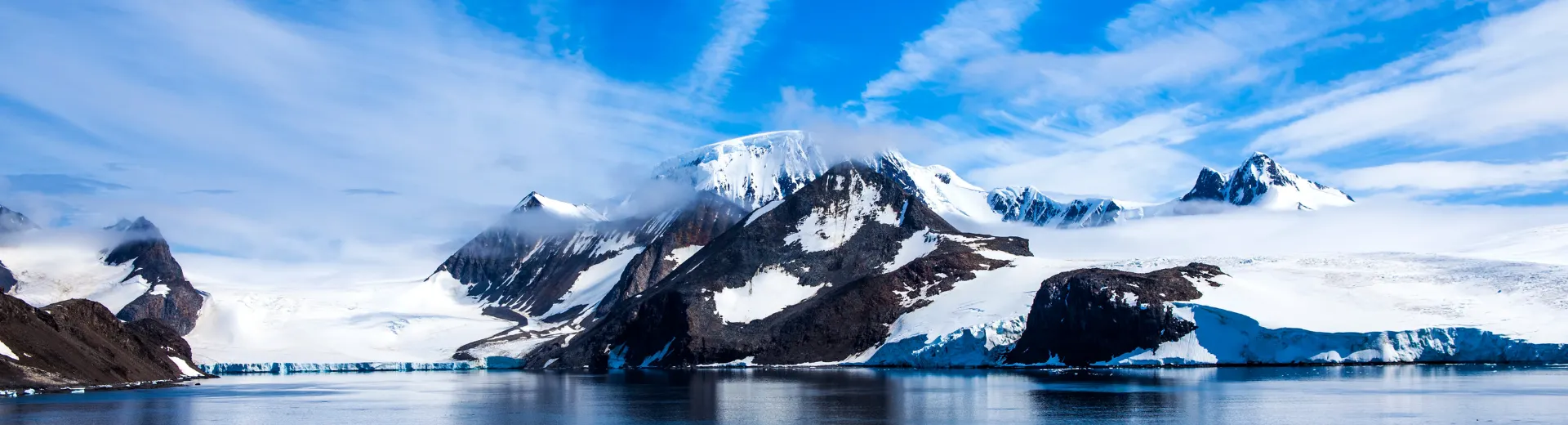 Imposante met sneeuw en ijs bedekte bergen onder een heldere lucht in Antarctica.