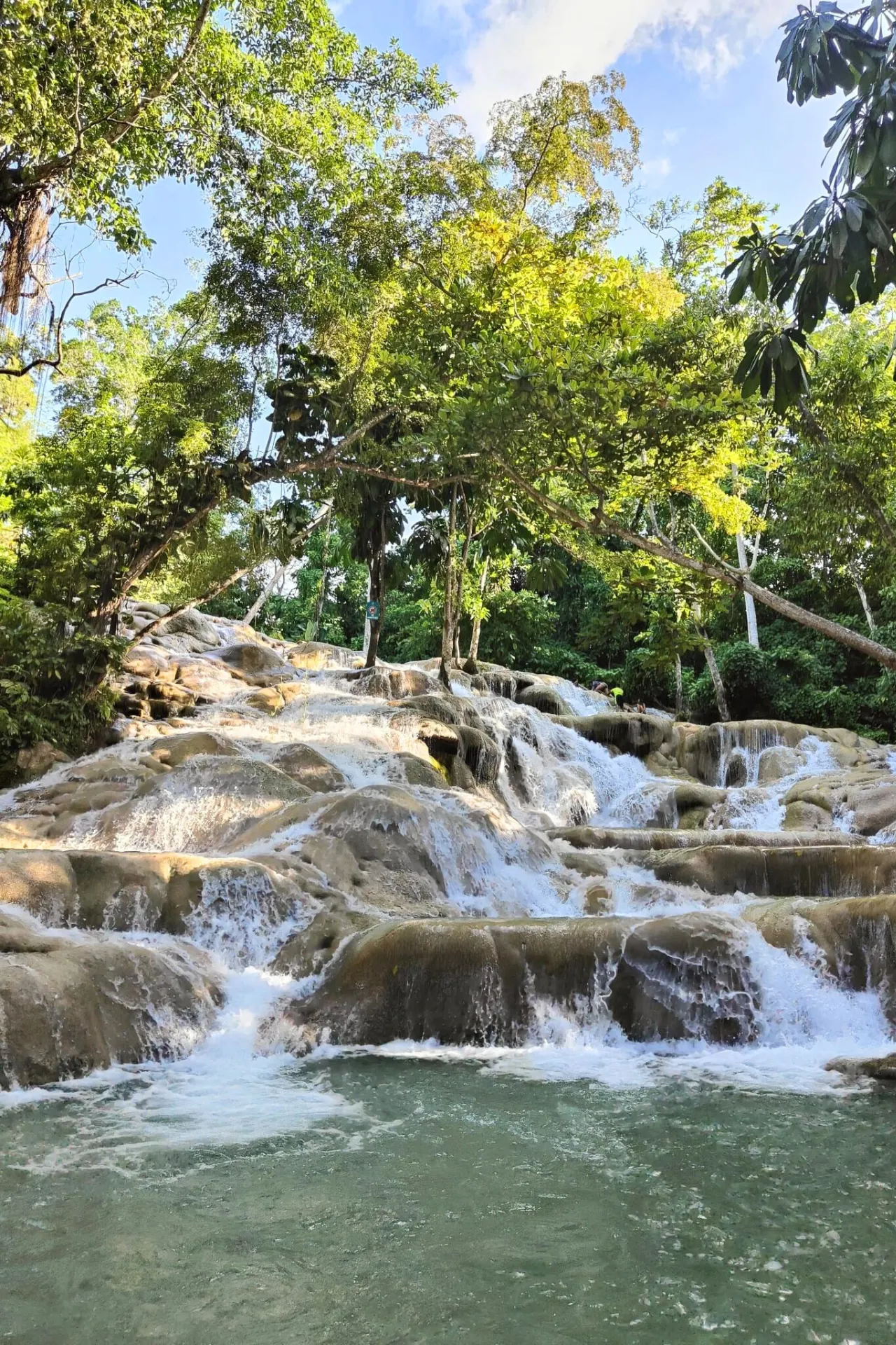 Indrukwekkende waterval in Jamaica: het stromende water van Dunn’s River Falls glijdt over tropische rotsformaties.