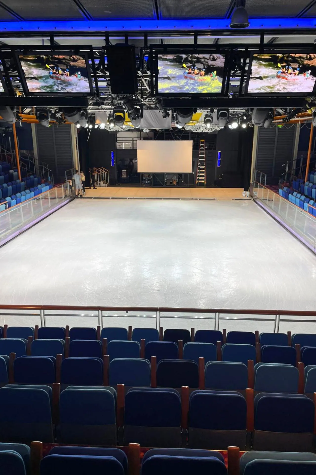 IJsbaan aan boord van de Independence of the Seas, met een glanzende ijsvloer, stoelen rondom en schermen boven de baan.
