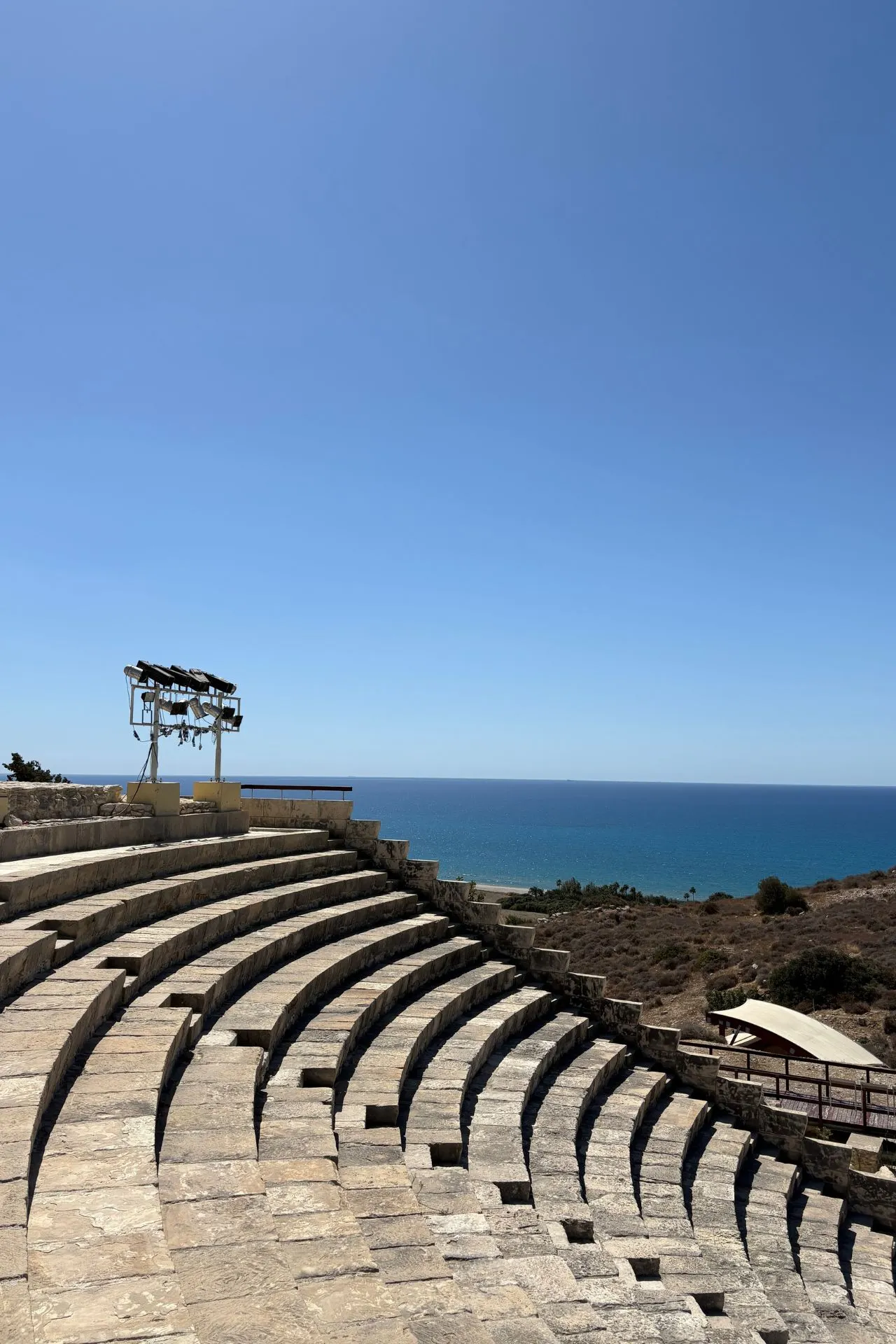 Oude stenen tribunes van het amfitheater van Kourion met uitzicht op de Middellandse Zee en een heldere blauwe lucht.