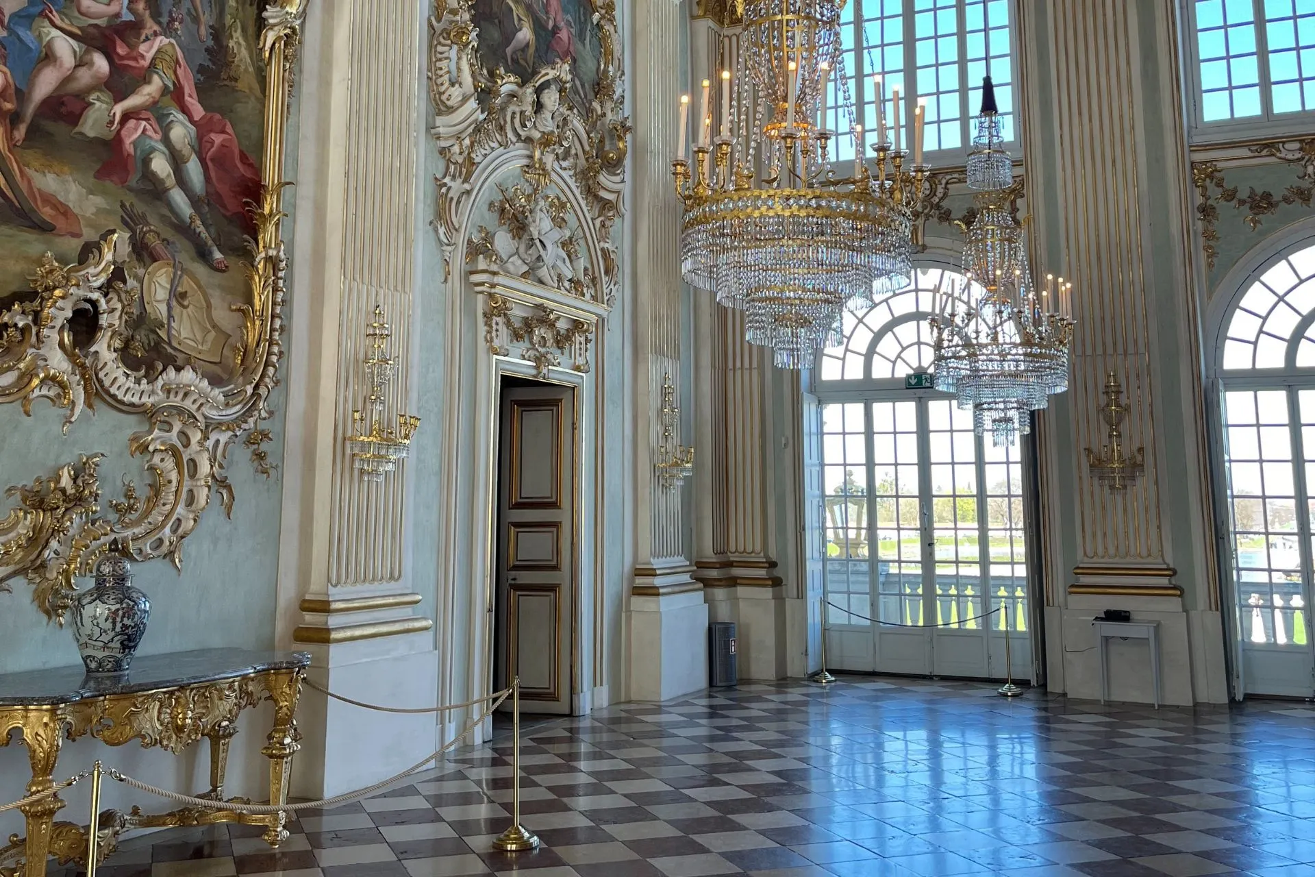 Een prachtig versierde balzaal in Schloss Nymphenburg, met indrukwekkende kroonluchters, gedetailleerde muurschilderingen en hoge ramen die uitkijken op de tuinen.
