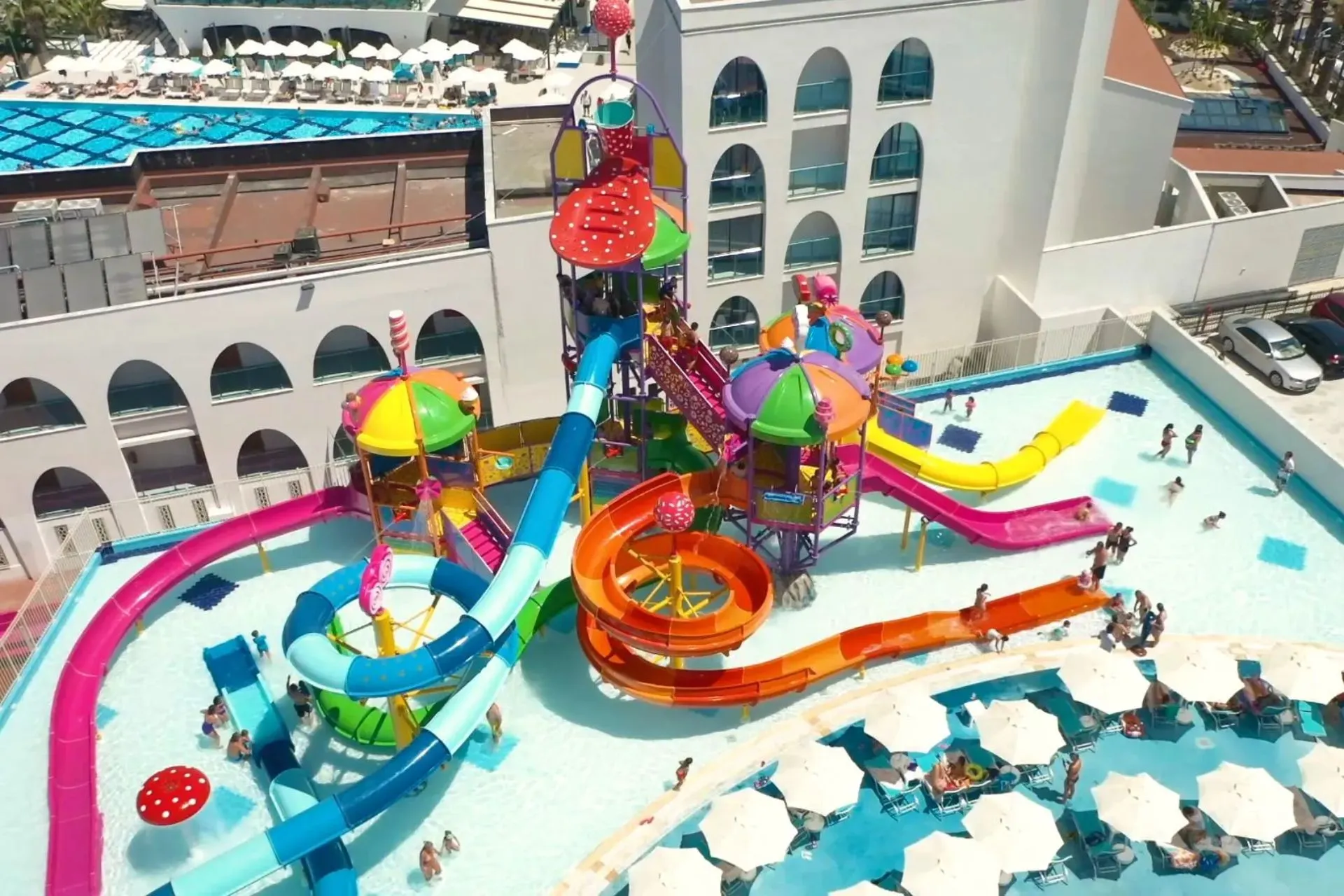 Kinderen spelen in een kleurrijk waterpark met glijbanen bij Infinity by Yelken Hotel in Kuşadası, Turkije.

