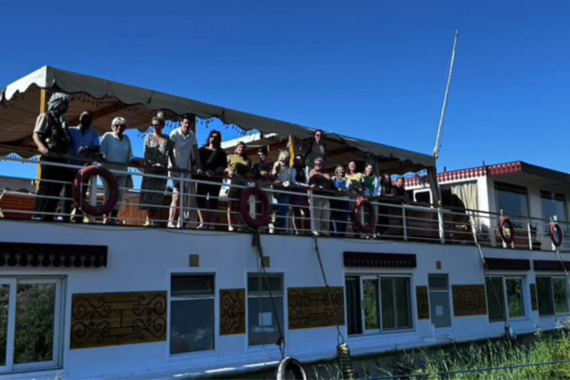 Mensen genieten van het uitzicht terwijl ze varen over de Nijl aan boord van een cruiseboot in Egypte.