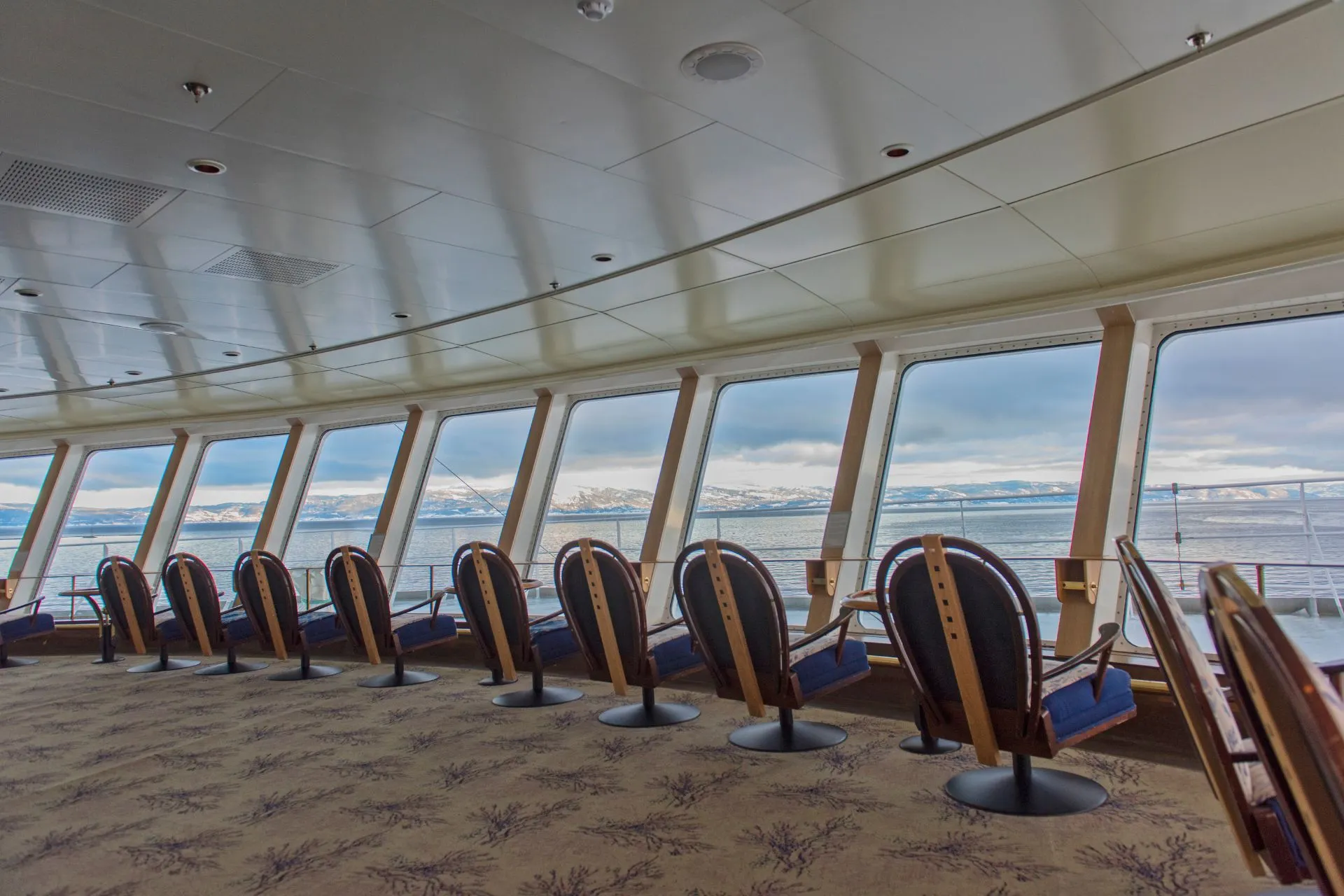 Panoramalounge aan boord van een Hurtigruten cruise vanuit Bergen, met uitzicht op het Arctische landschap tijdens een Hurtigruten kustreis in Noorwegen richting Svalbard.
