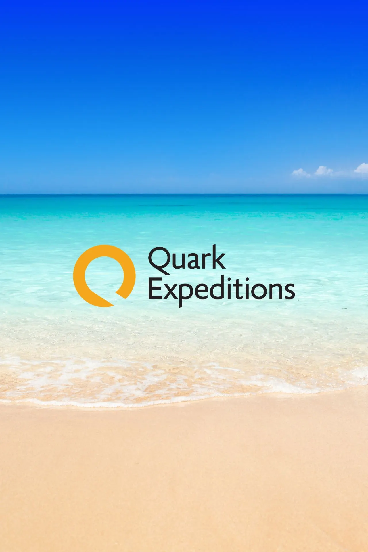 Logo van Quark Expeditions op een zonnig strand met helder turquoise water en blauwe lucht.