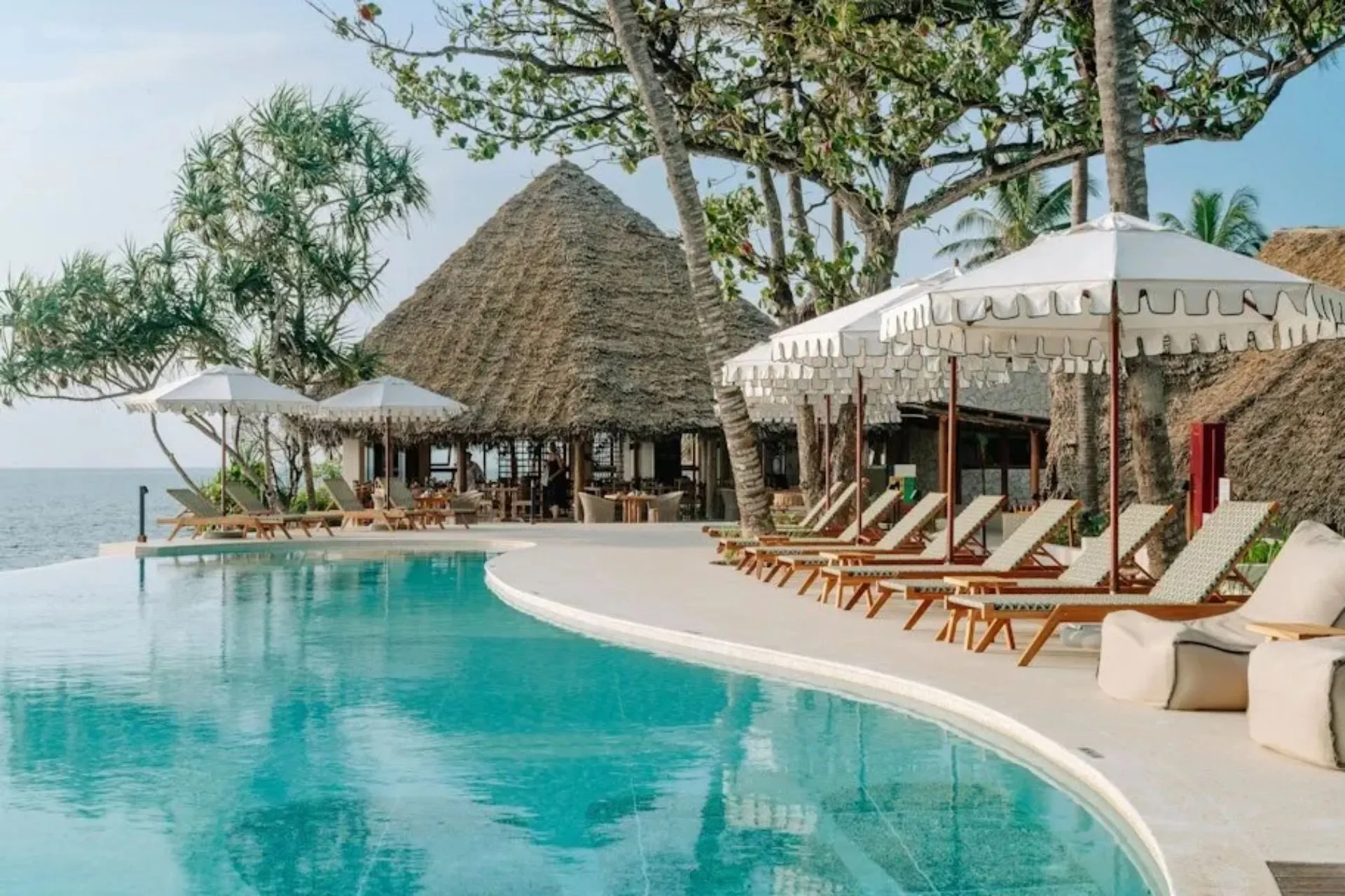Zwembad van Matemwe Attitude op Zanzibar met luxe ligbedden, rieten daken en uitzicht op de Indische Oceaan. Dit stijlvolle adults only resort aan de oostkust van Zanzibar combineert rust, natuur en een ontspannen sfeer. De tropische omgeving en kleinschalige opzet maken het een ideale bestemming voor koppels.