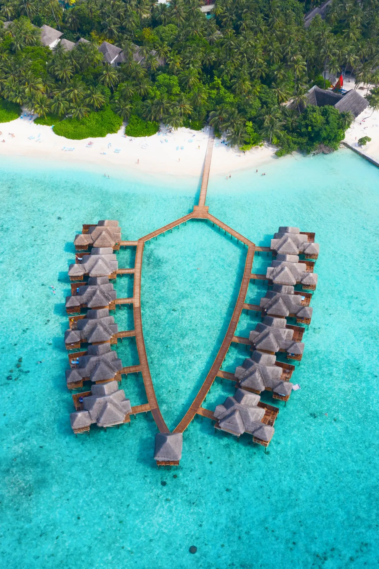 "Luxe waterbungalows op palen in kristalhelder turquoise water, omringd door tropische palmbomen en wit zandstrand. Perfecte vakantiebestemming voor een romantische huwelijksreis, ontspannende zonvakantie of exclusieve resortervaring. Geniet van privacy, comfort en adembenemende uitzichten in een paradijselijke omgeving. Ideaal voor reizigers die op zoek zijn naar luxe, rust en tropische schoonheid op een exotisch eiland zoals de Malediven."