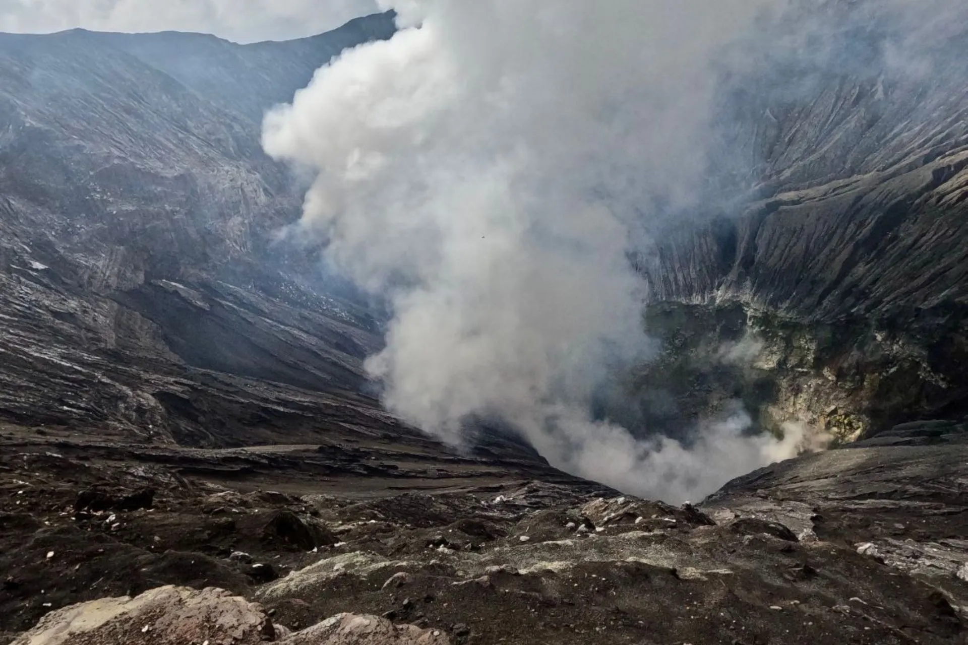 De dampende krater van de Bromo-vulkaan op Java, met opstijgende rookwolken.