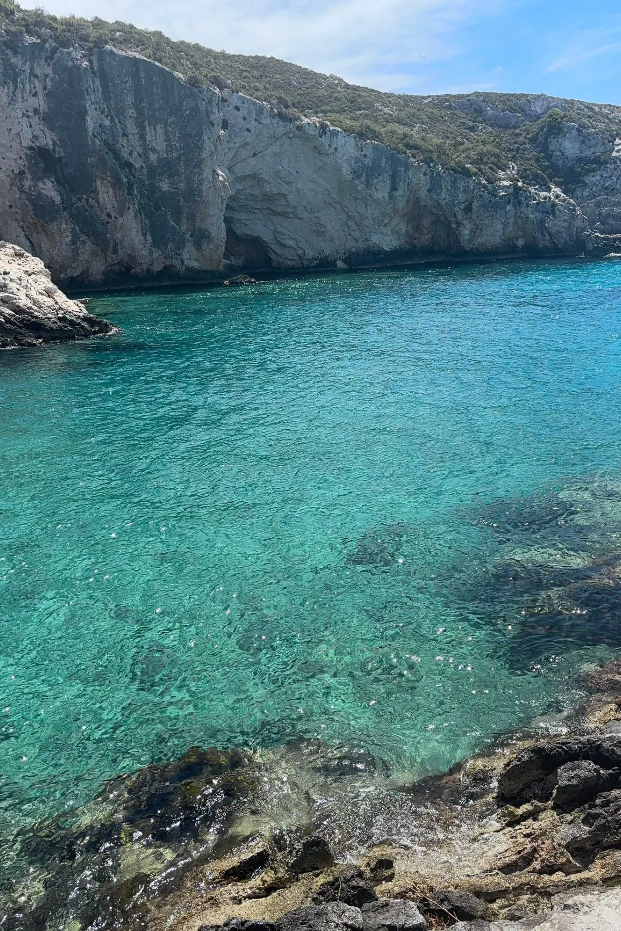 Close-up van turquoise zeewater en rotsachtige kustlijn op Zakynthos, ideaal om te snorkelen.