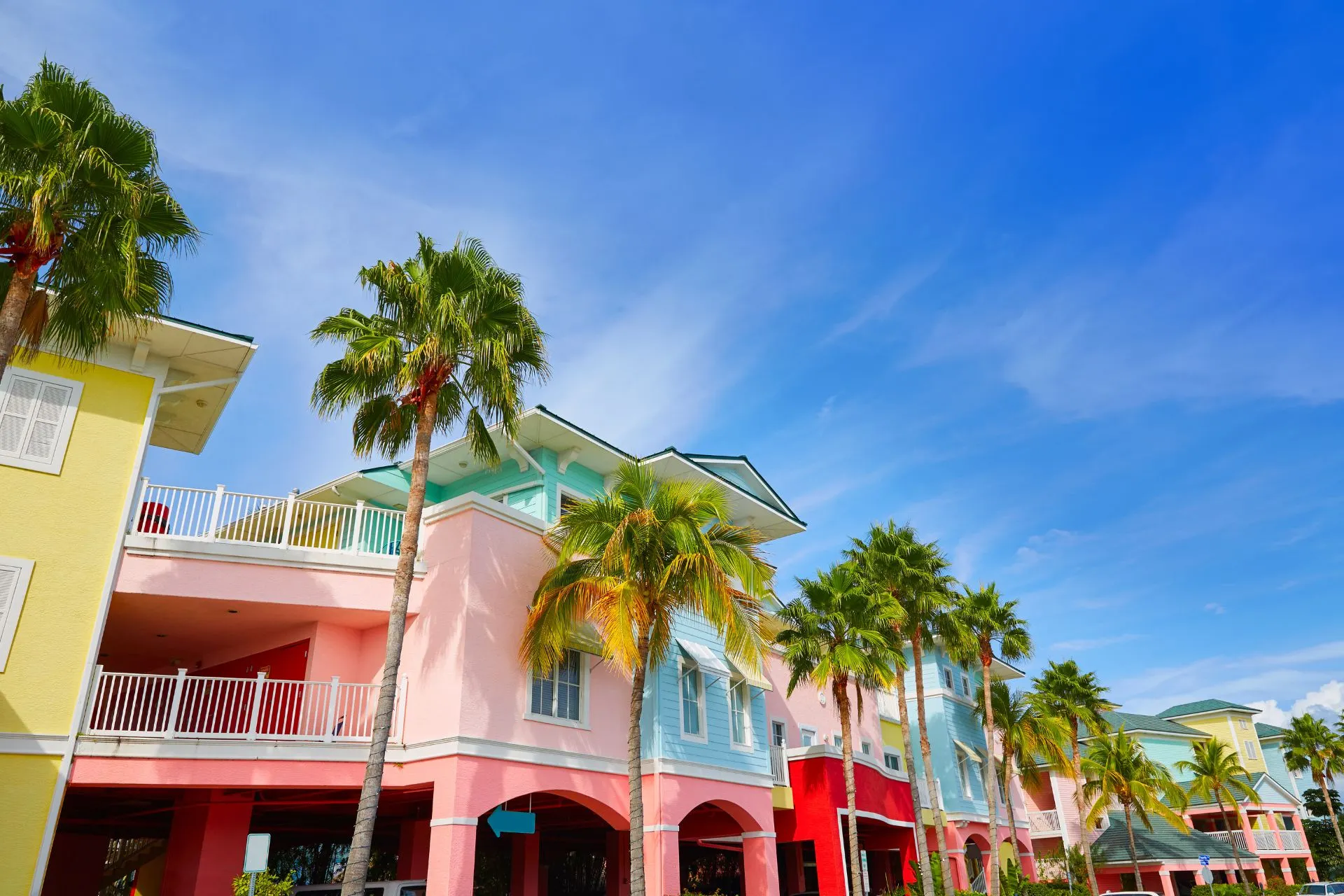 Gekleurde huizen in een zonnige straat in Florida, met palmbomen en een vrolijke, tropische sfeer.