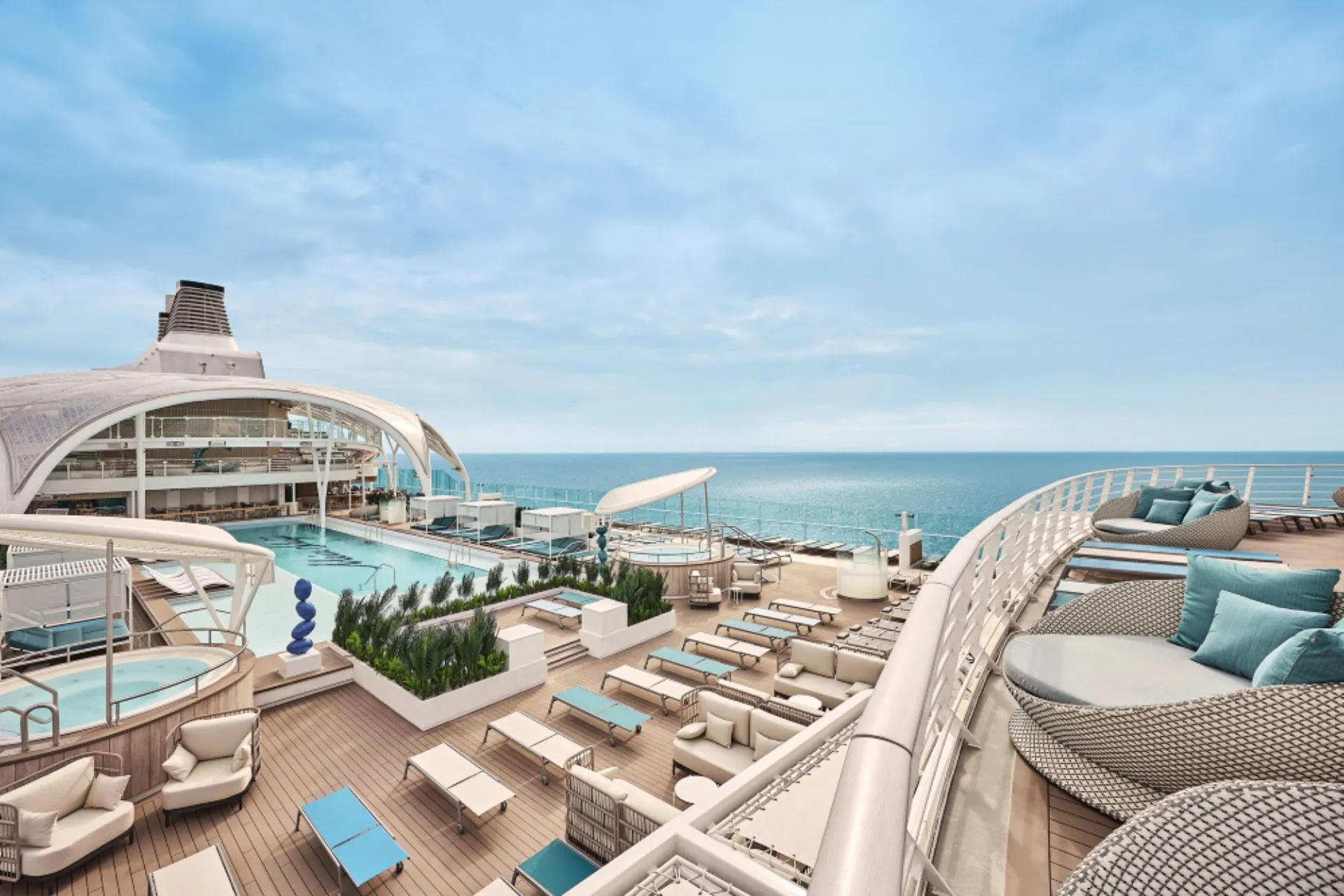 Zonnedek aan boord van een modern Mein Schiff cruiseschip van TUI Cruises met ligbedden, zwembad en uitzicht over zee. Deze Premium All Inclusive cruise biedt ontspanning, comfort en luxe faciliteiten in een ongedwongen sfeer.
