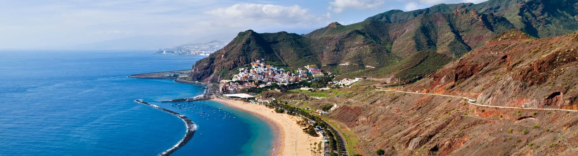Panoramisch uitzicht op het noorden van Tenerife met het gouden strand van Playa de Las Teresitas, helderblauwe oceaan en groene berglandschappen nabij Santa Cruz de Tenerife.