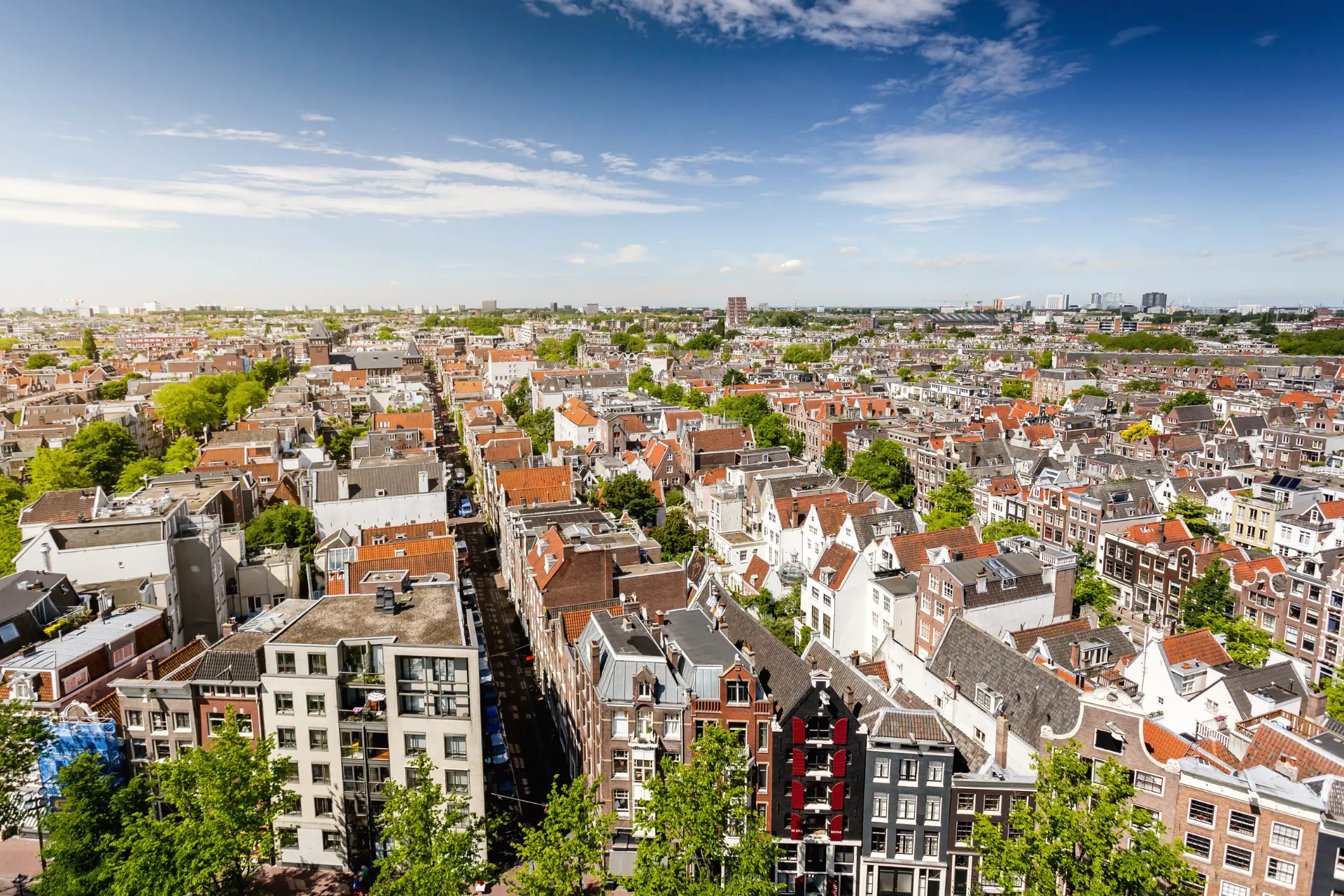 Luchtfoto van Amsterdam met iconische gebouwen, een prachtige stad om te bezoeken of als startpunt voor vluchten vanaf Schiphol naar bestemmingen wereldwijd.