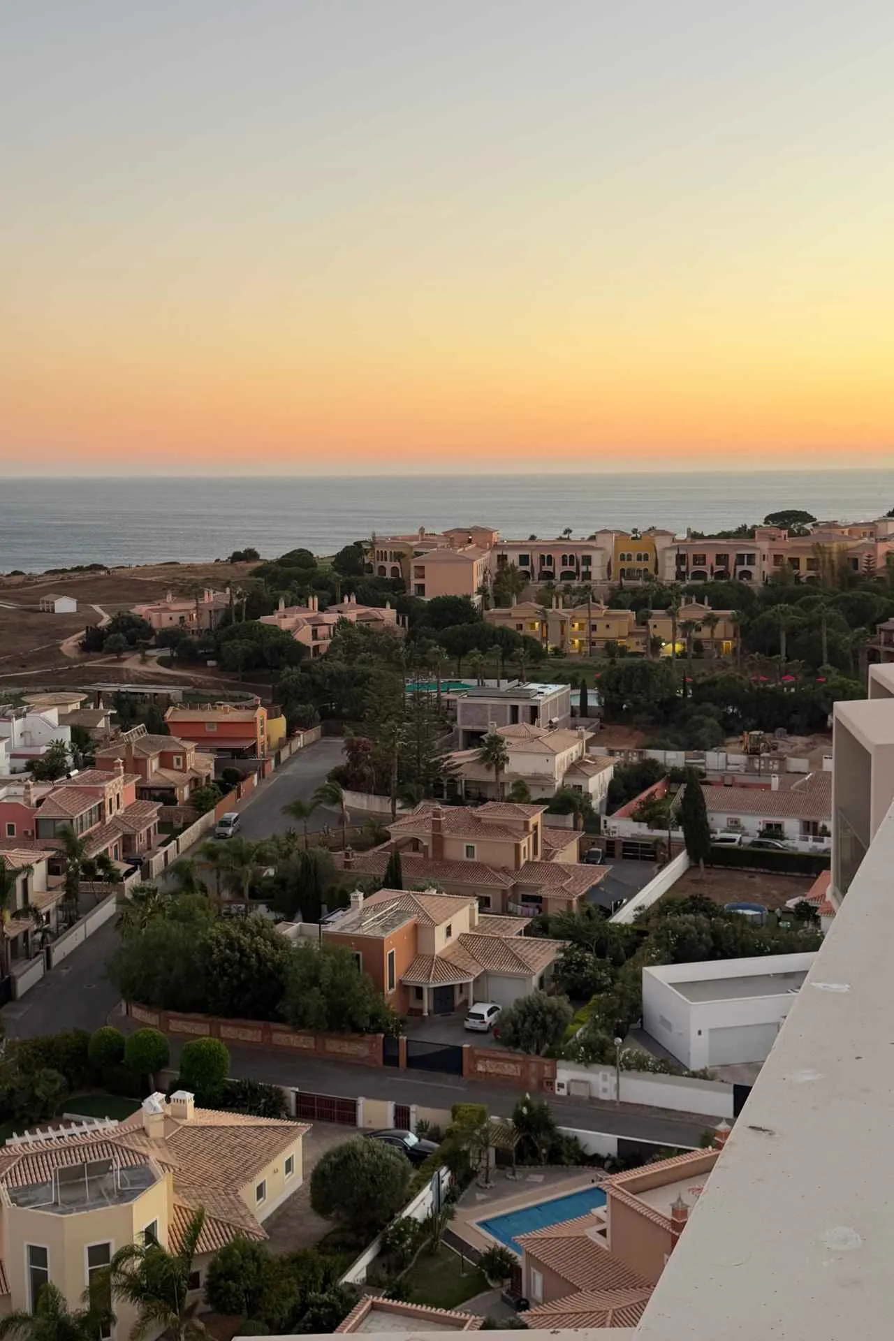 Uitzicht over de kust en kleurrijke villa’s van de Algarve tijdens zonsondergang in Portugal.
