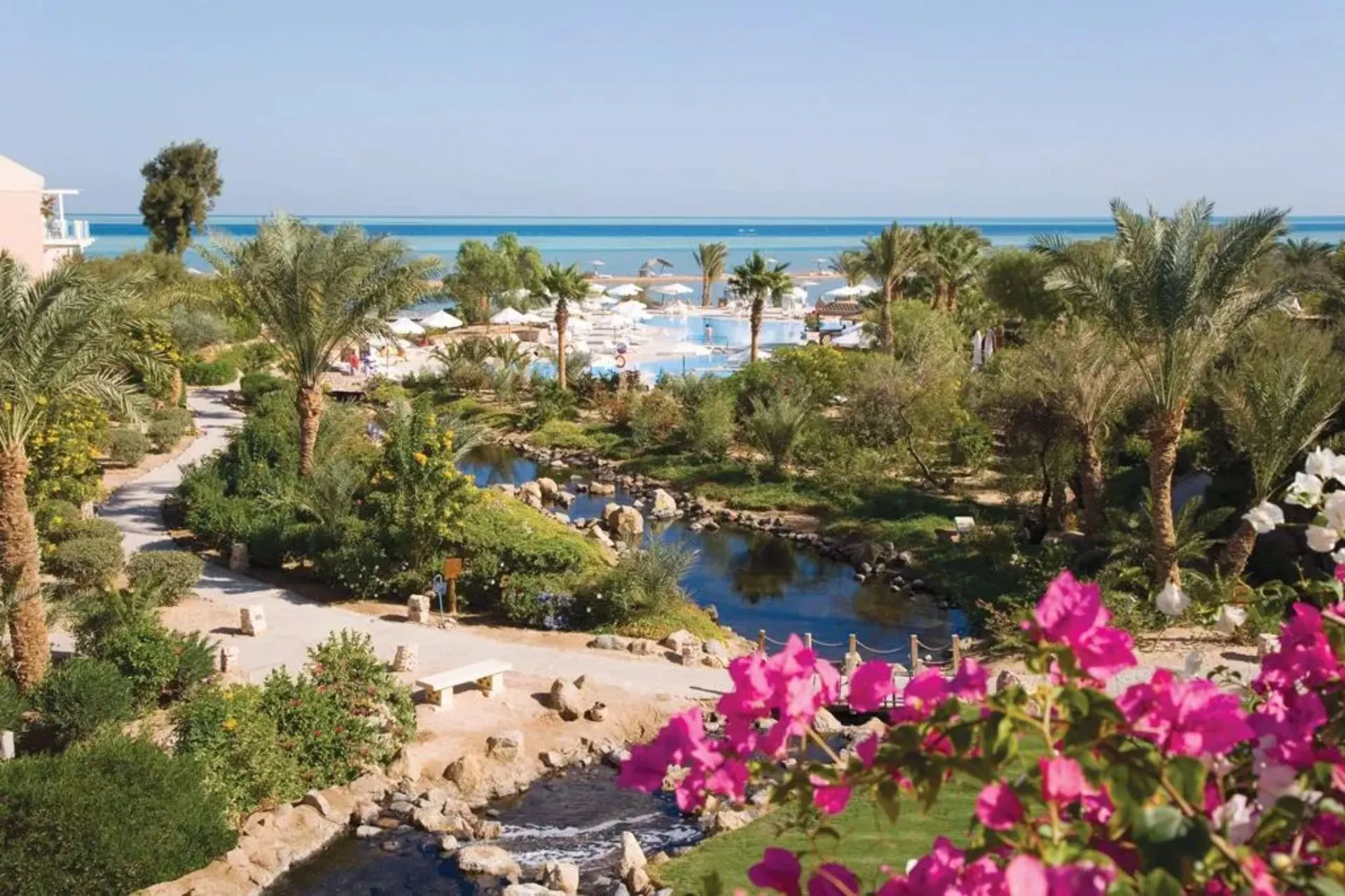 Uitzicht over Mövenpick Resort & Spa El Gouna met tropische tuin, zwembad en Rode Zee op de achtergrond