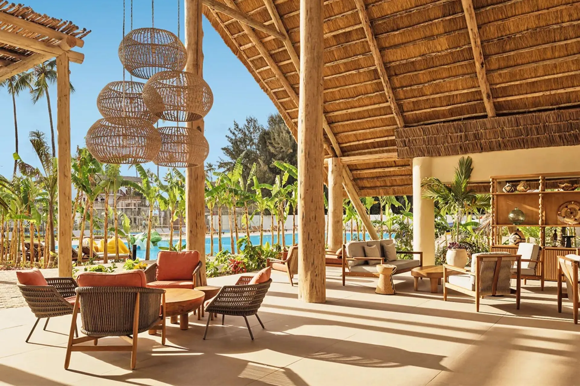 De sfeervolle open lobby van Jaz Elite Aurora Beach Resort op Zanzibar combineert natuurlijke materialen, houten details en een moderne Afrikaanse uitstraling. Vanuit de lounge kijk je uit op de tropische tuin en het zwembad, wat direct zorgt voor een luxe en ontspannen vakantiesfeer aan de kust van Zanzibar.