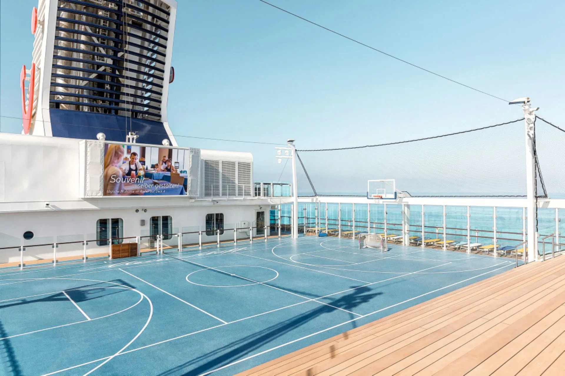 Sport- en recreatiedek op een Mein Schiff schip van TUI Cruises met basketbalveld en zeezicht. Ideaal voor actieve reizigers die tijdens een Premium All Inclusive cruise sport, ontspanning en comfort willen combineren.
