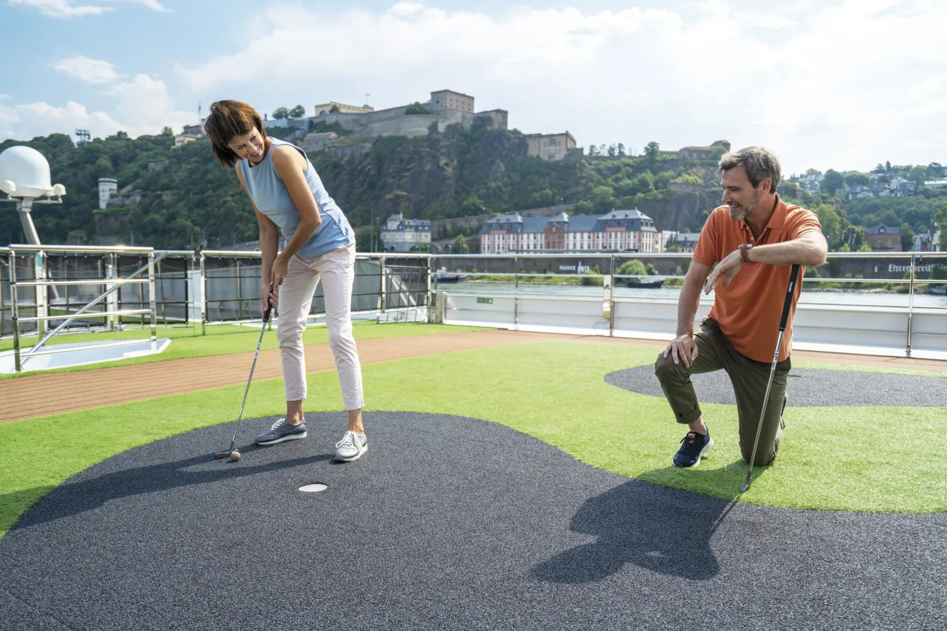 Twee mensen spelen golf op het dek van het Emerald Cruises schip, genietend van een ontspannen activiteit aan boord.