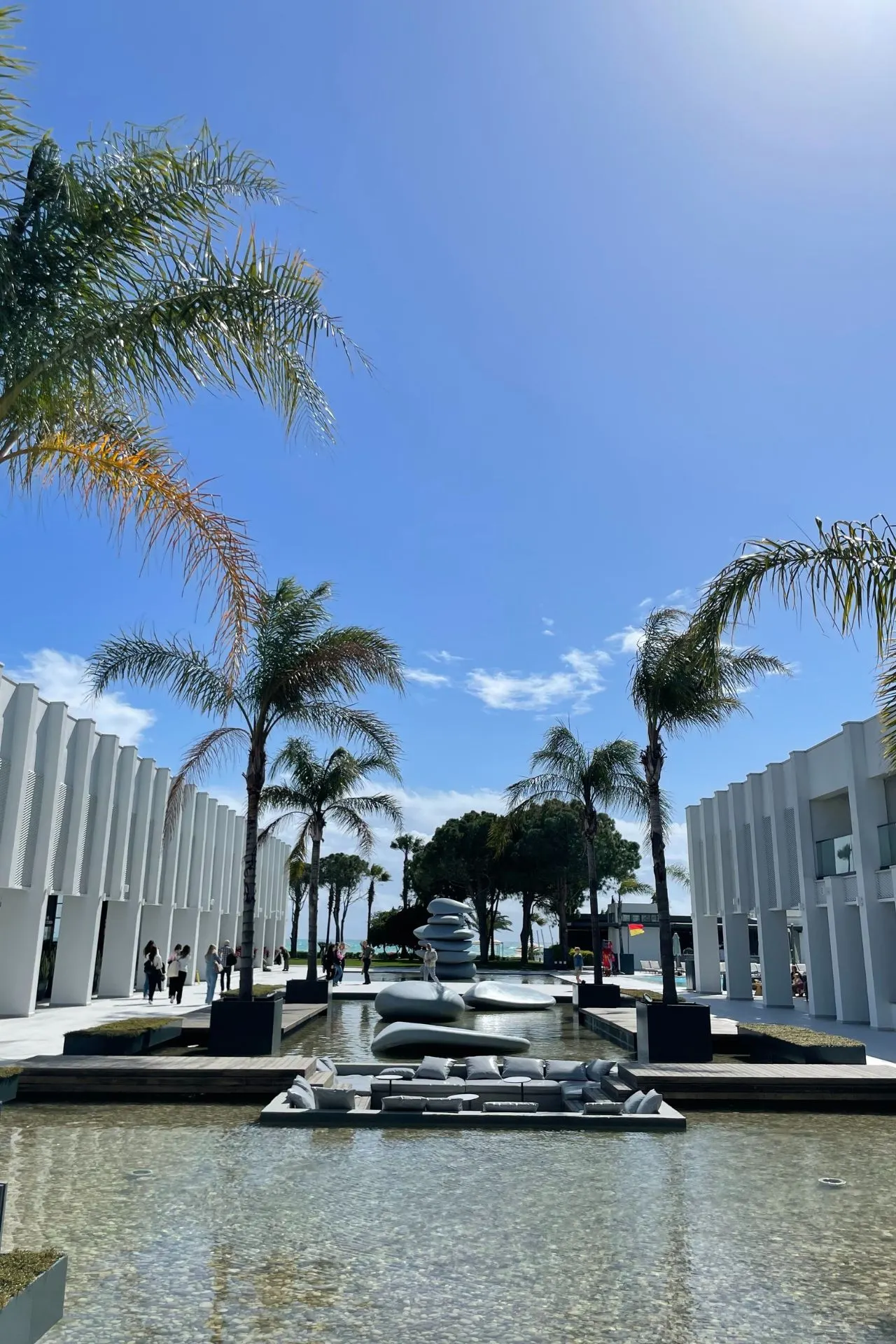 Hotel in Antalya, omringd door helder water en palmbomen, met elegante witte muren voor een tropisch paradijsgevoel